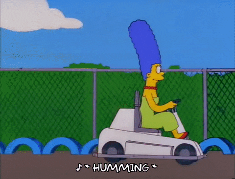 Animated gif of Marge Simpson driving a go-kart slowly as she's passed by others driving much faster