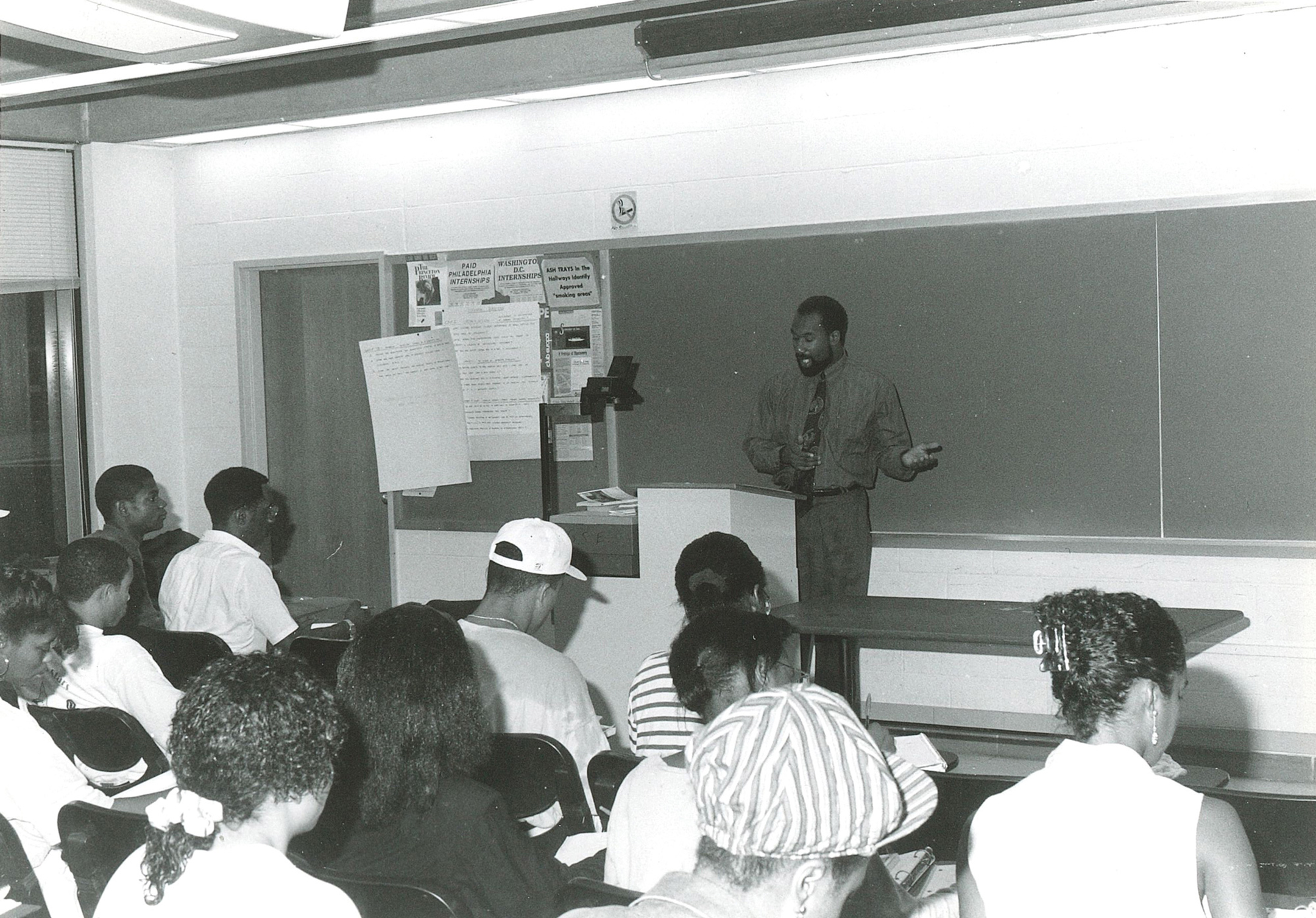Black and white photo of Herman Beavers teaching at the front of a classroom