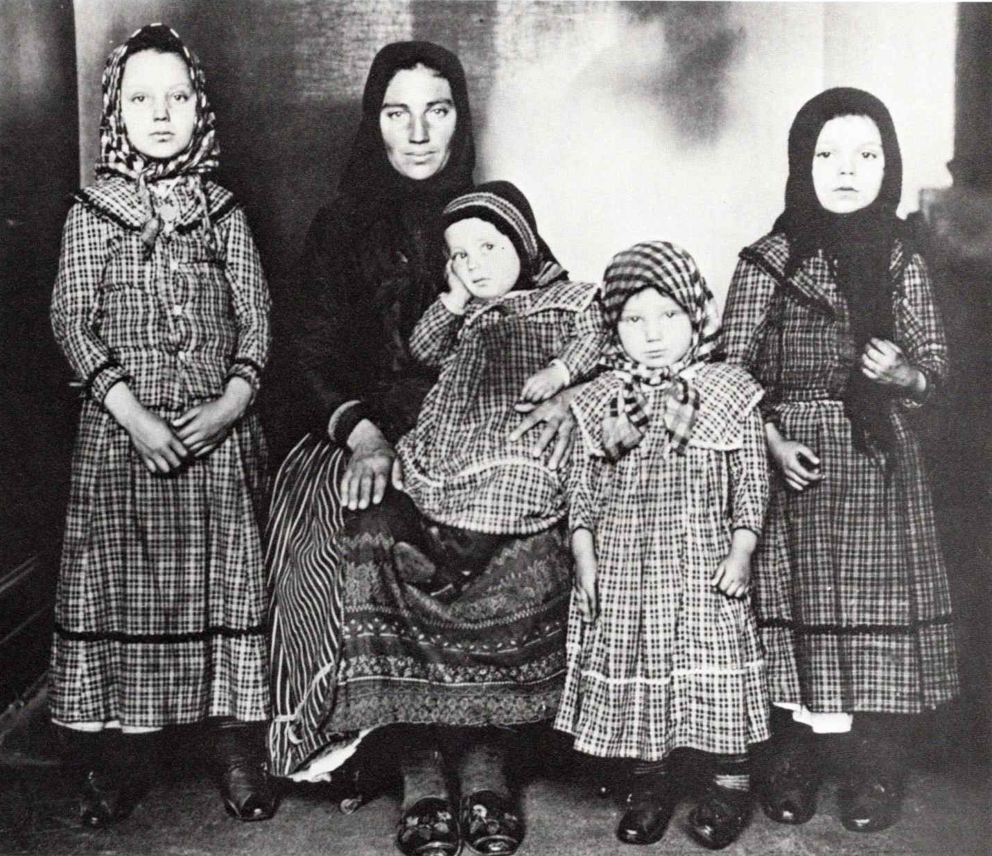 a black and white photo taken in 1910 of a family of hungarian immigrants, four children and their mother, arriving at Ellis Island