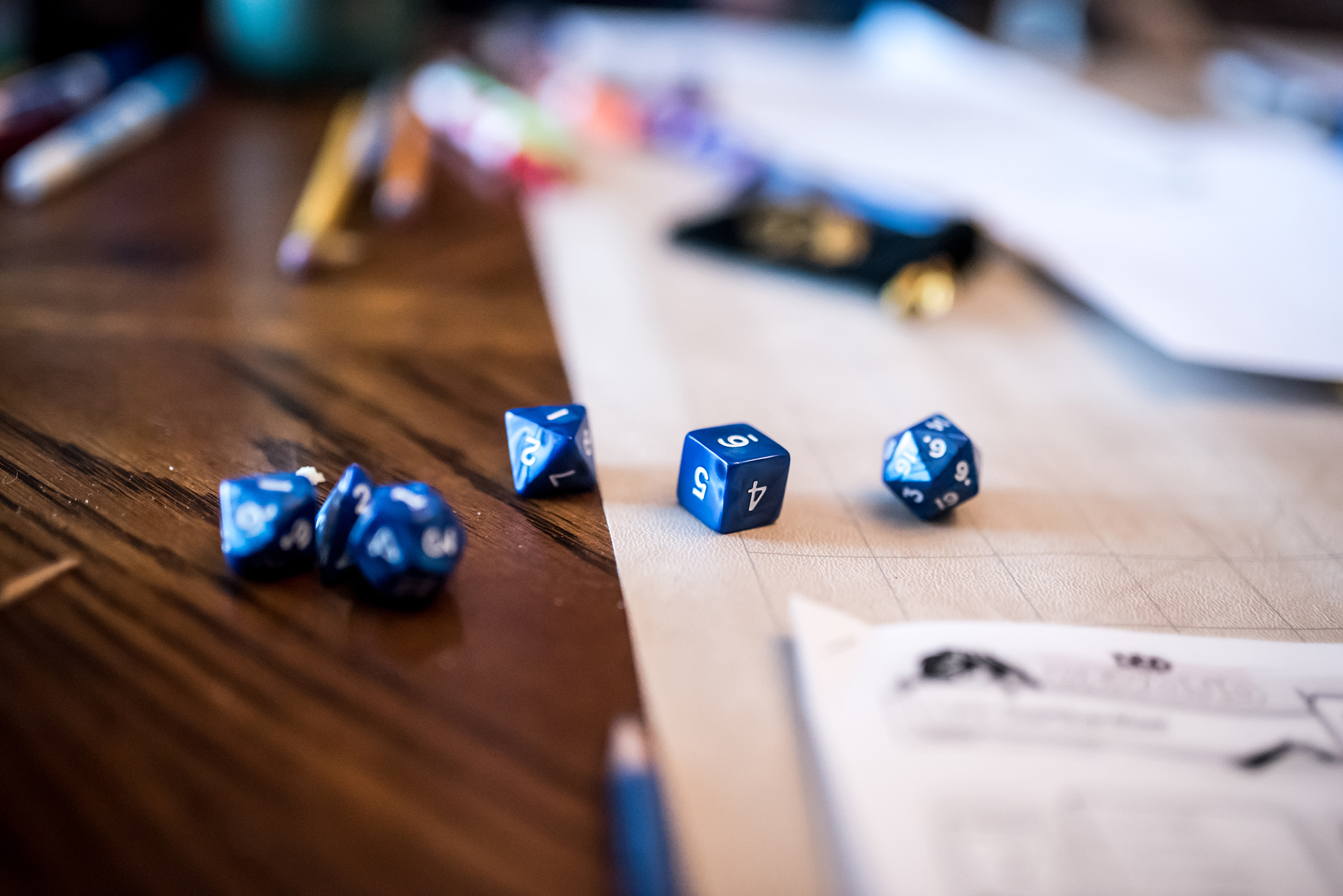 Tabletop with dice, pencils, papers and other tools for a role playing game of dungeons and dragons in progress