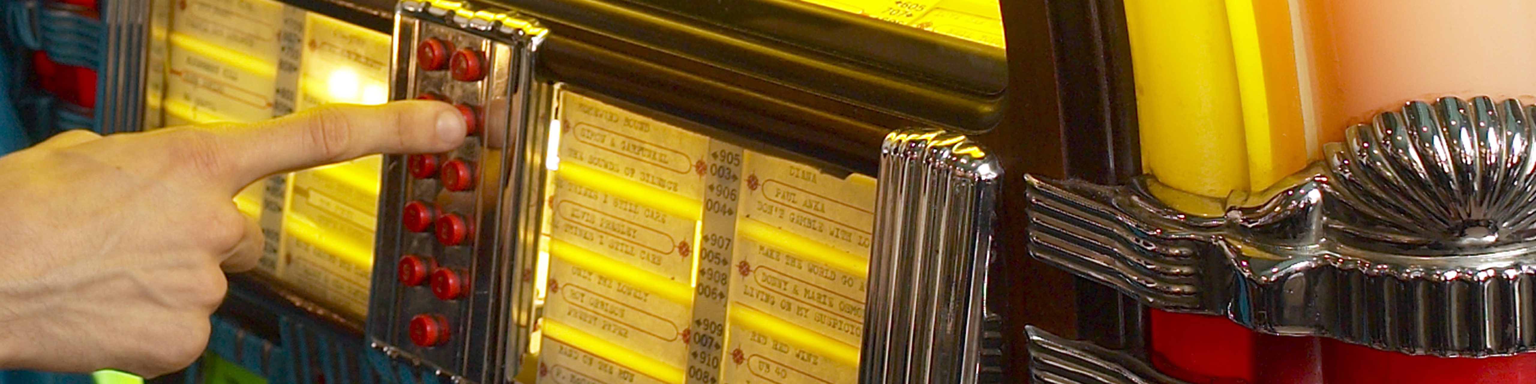 a close up of a finger pressing a button on a jukebox