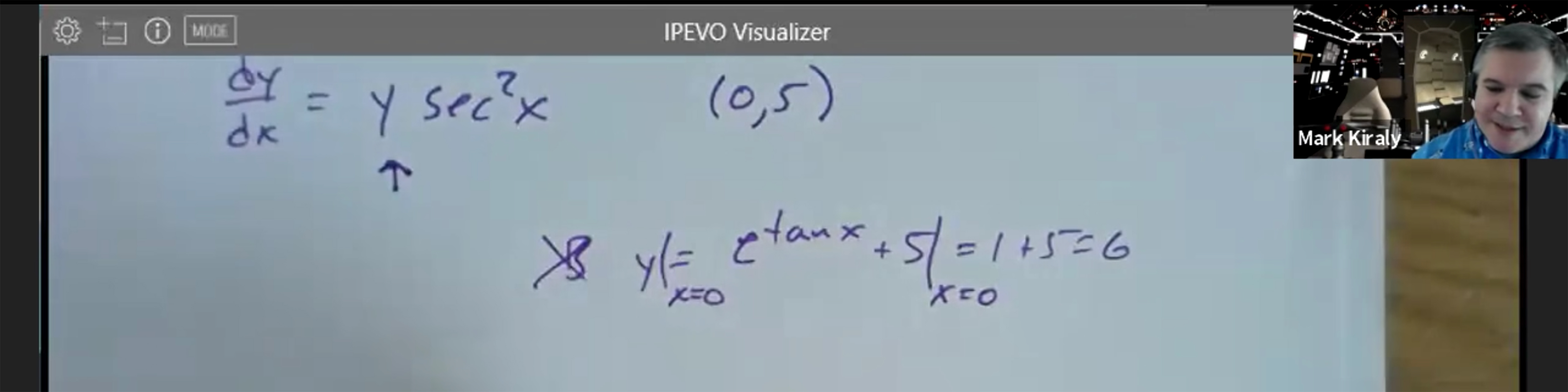 a screenshot from a virtual AP Calculus AB class showing an equation being worked out on paper and the teacher in a small box at the top right