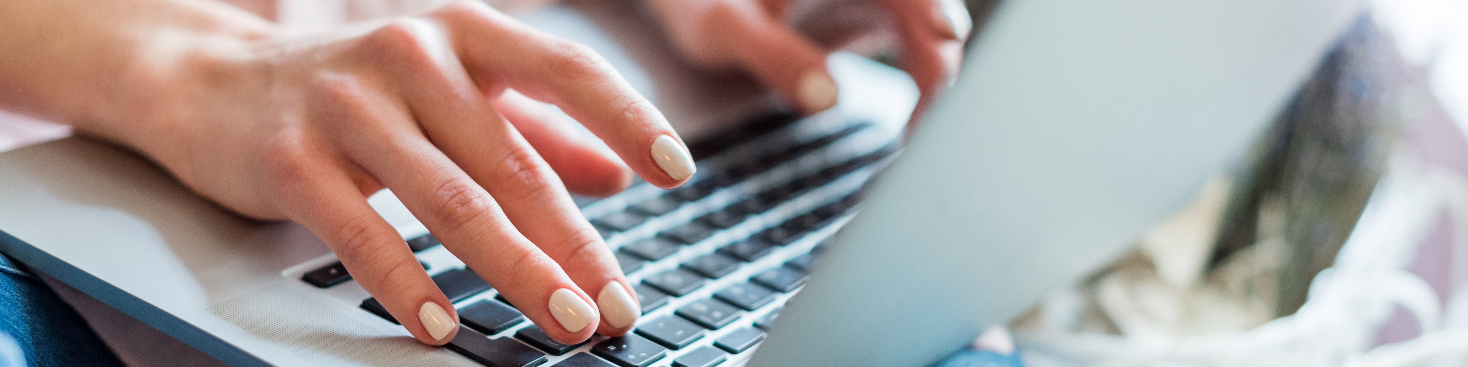 closeup of two female hands typing on a laptop computer
