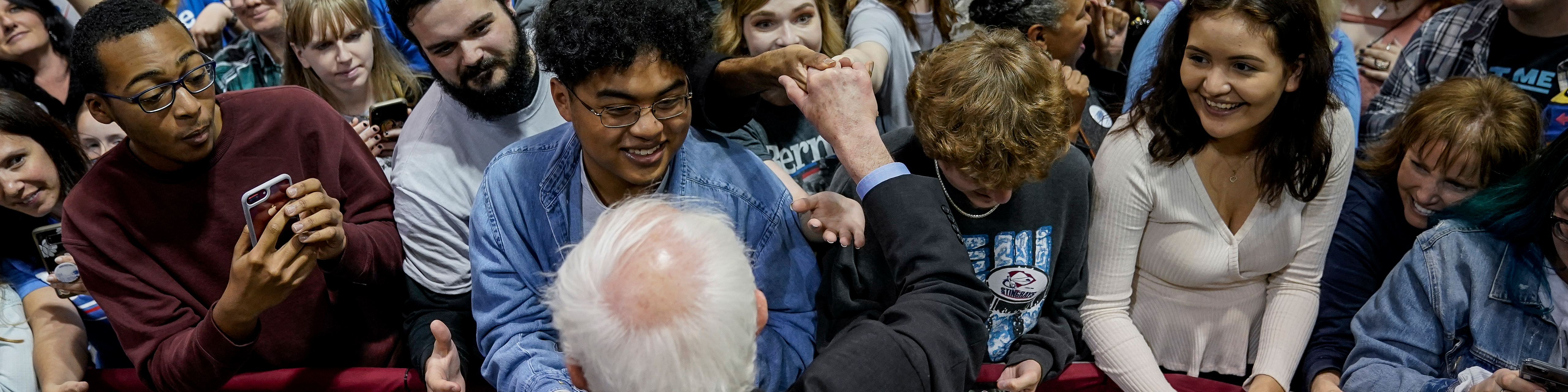 A row of young voters are greeted by presidential candidate senator bernie sanders