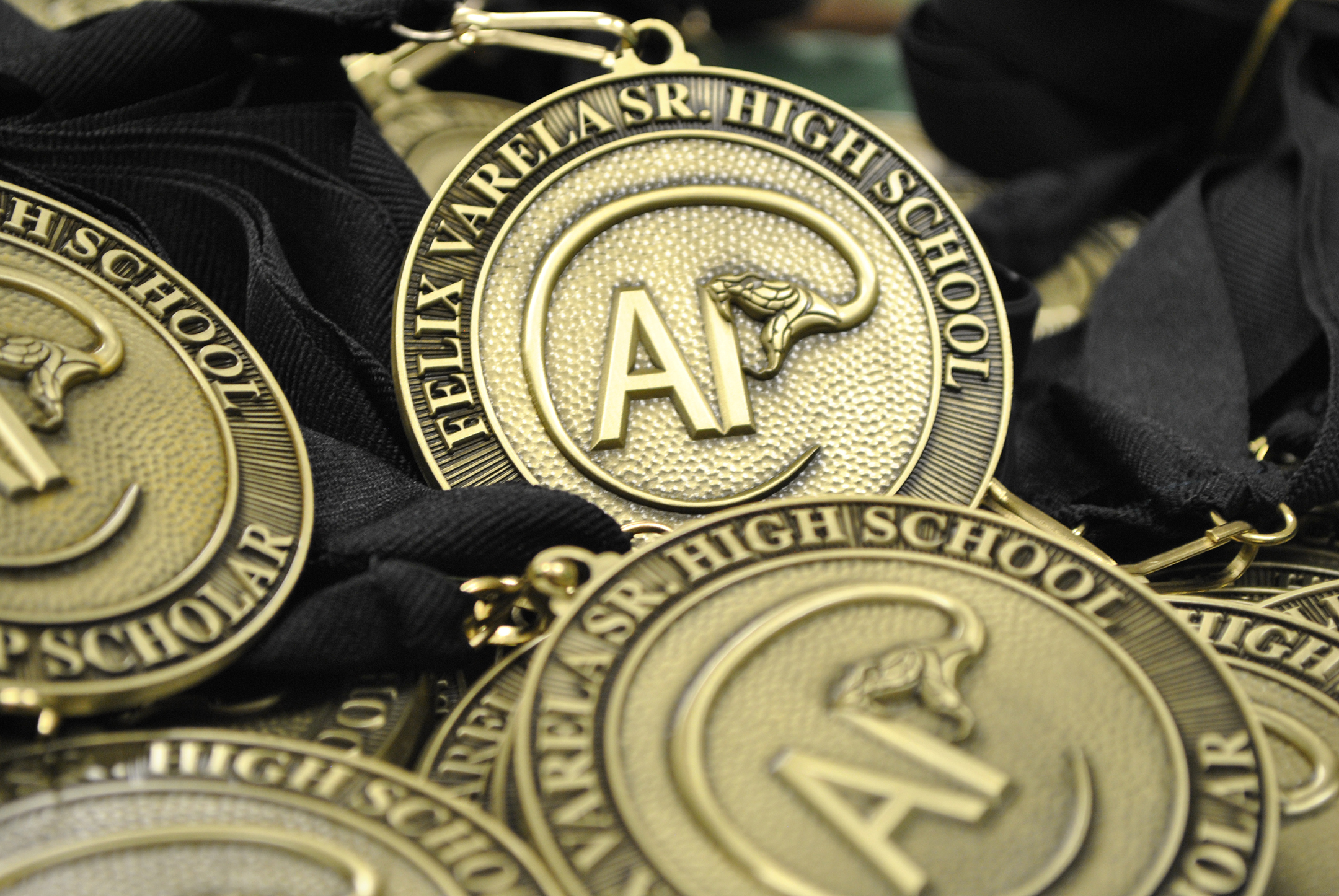 a pile of medals with Felix Varela Senior High School's custom ap logo