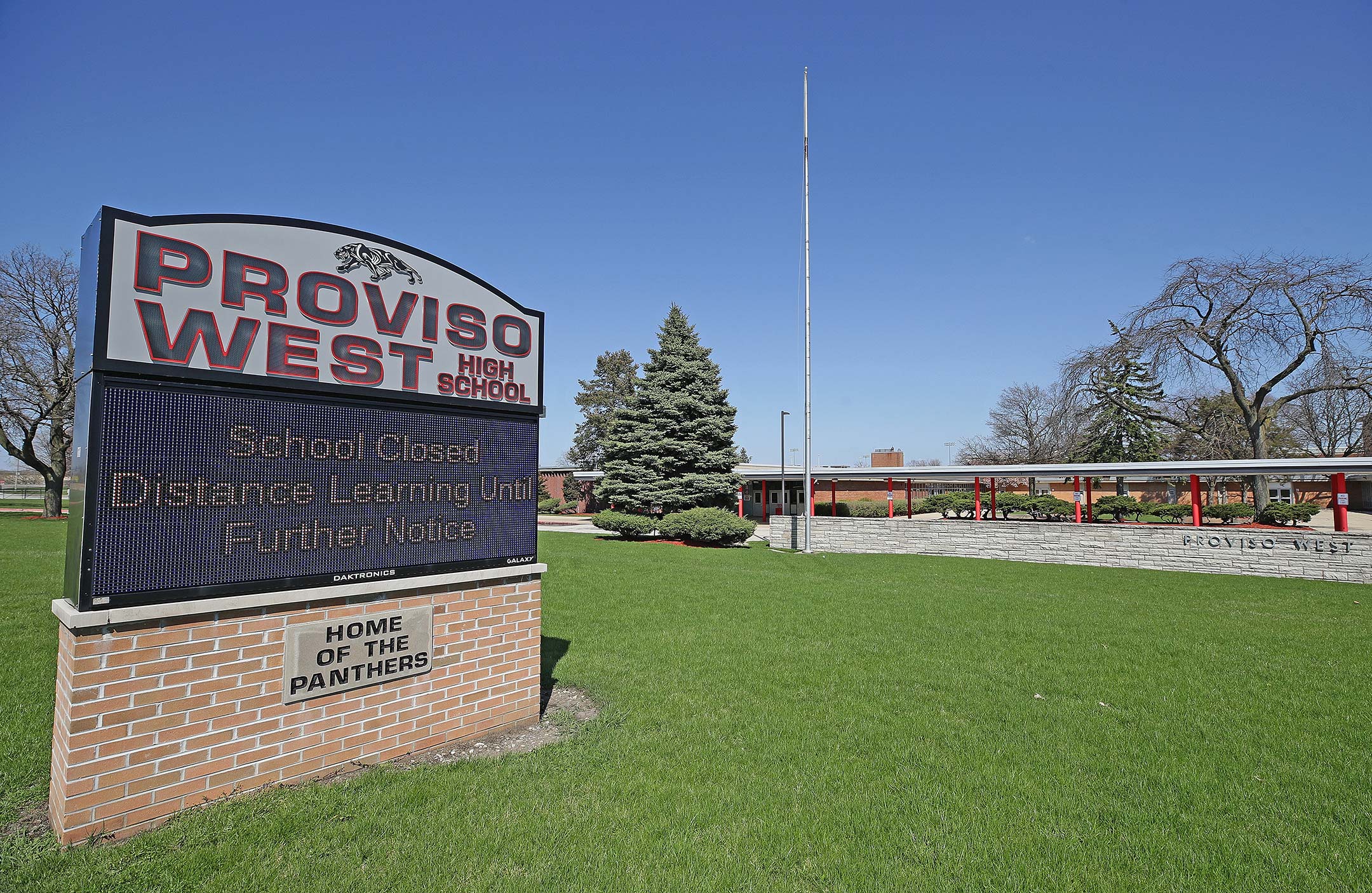 Photograph of a high school digital sign on a green and empty lawn