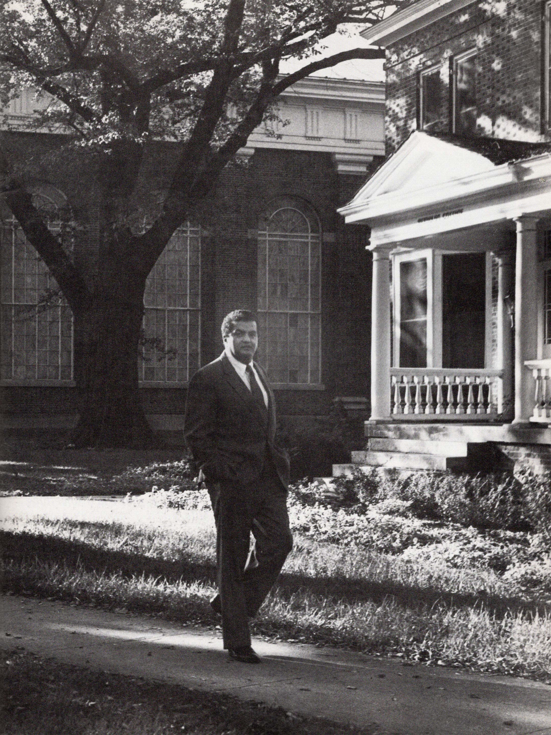 black and white photograph of donald m stewart standing on a college campus