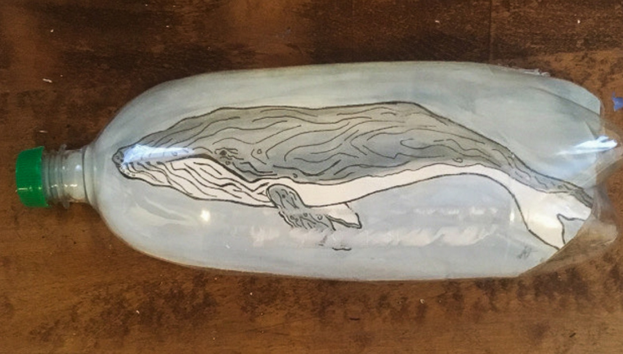 a plastic bottle with a whale painted on it