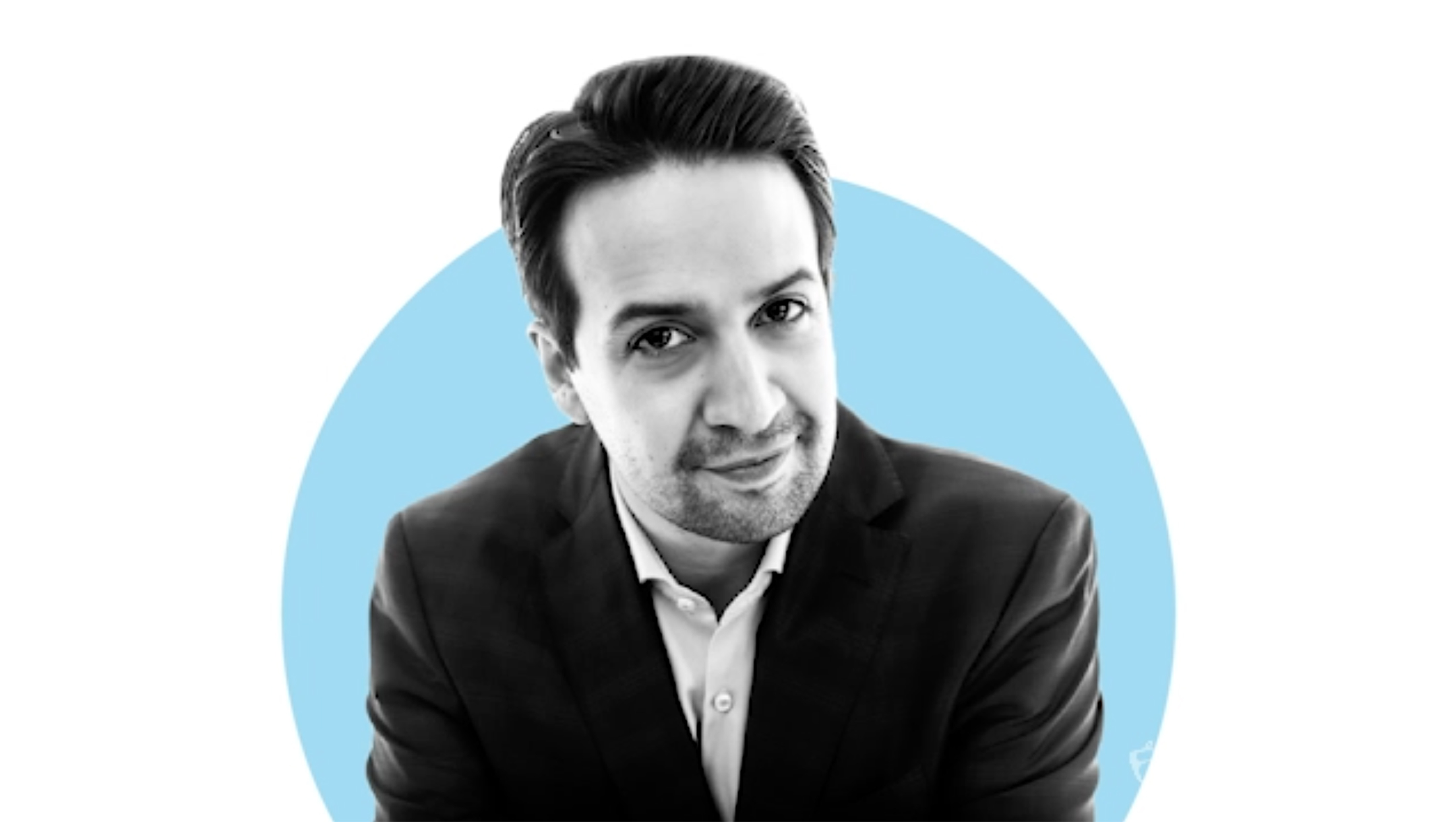 Black and white photo of Lin Manuel miranda in front of a blue dot against a white background