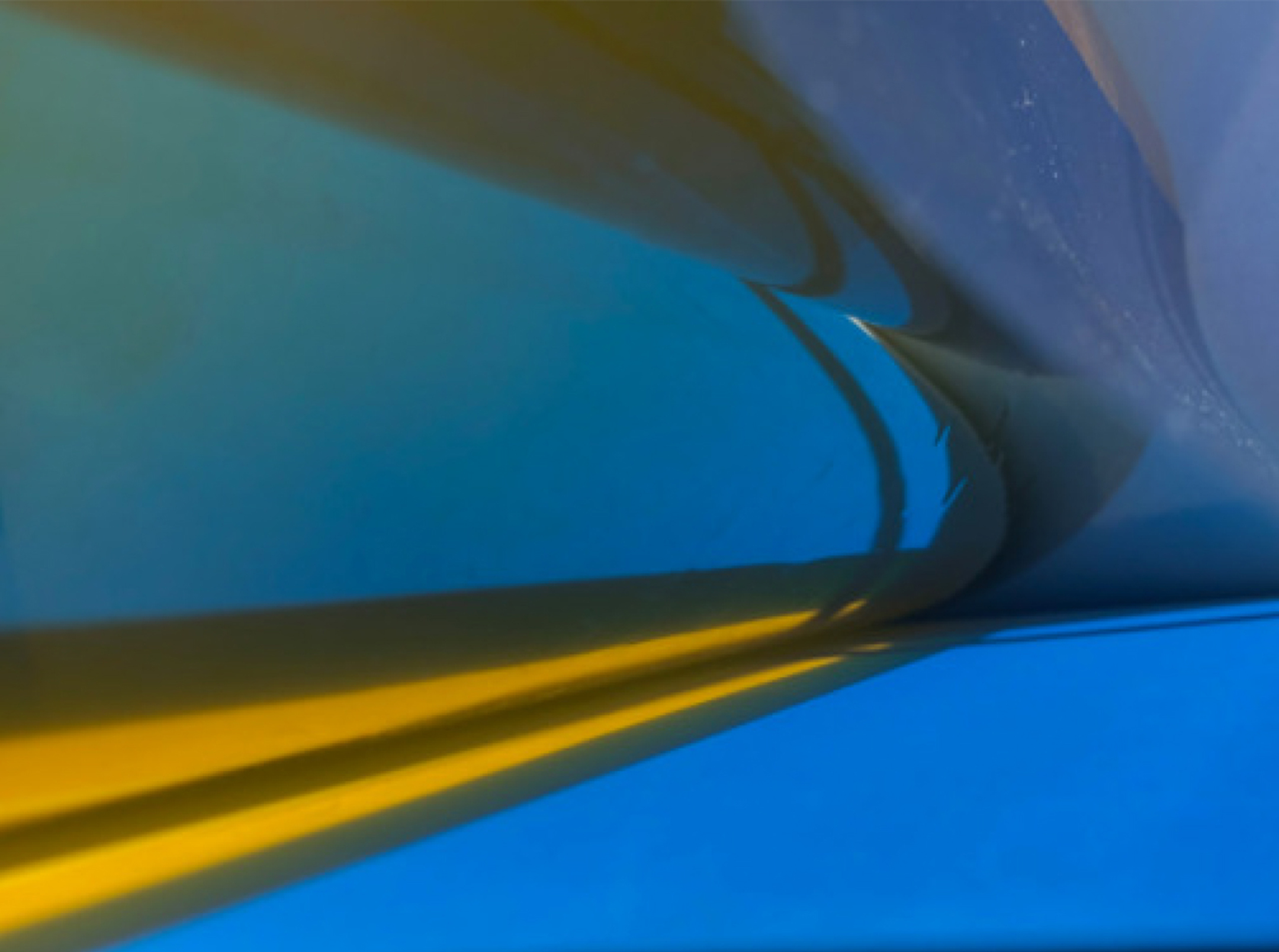 Abstract image of a streak of yellow against a curvy blue background