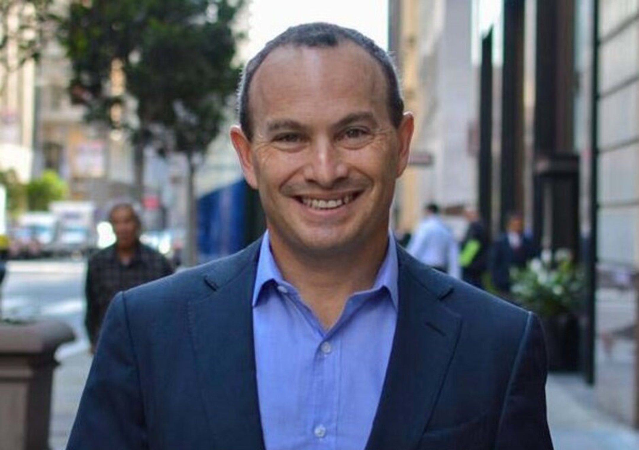 Photo of Evan Marwell smiling in a blue suit and blue shirt