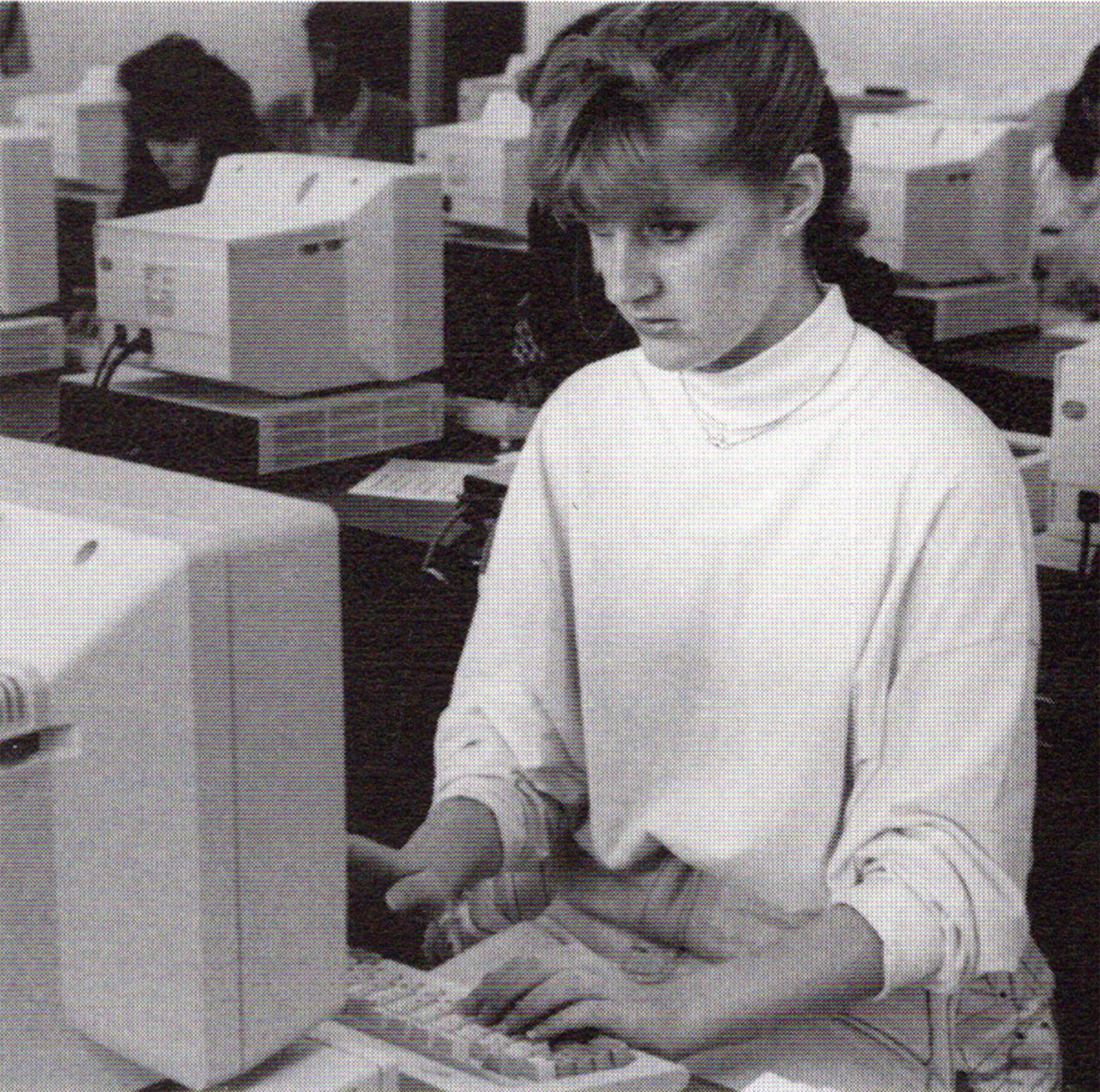 Black and white photo of a white female high school student working at a computer