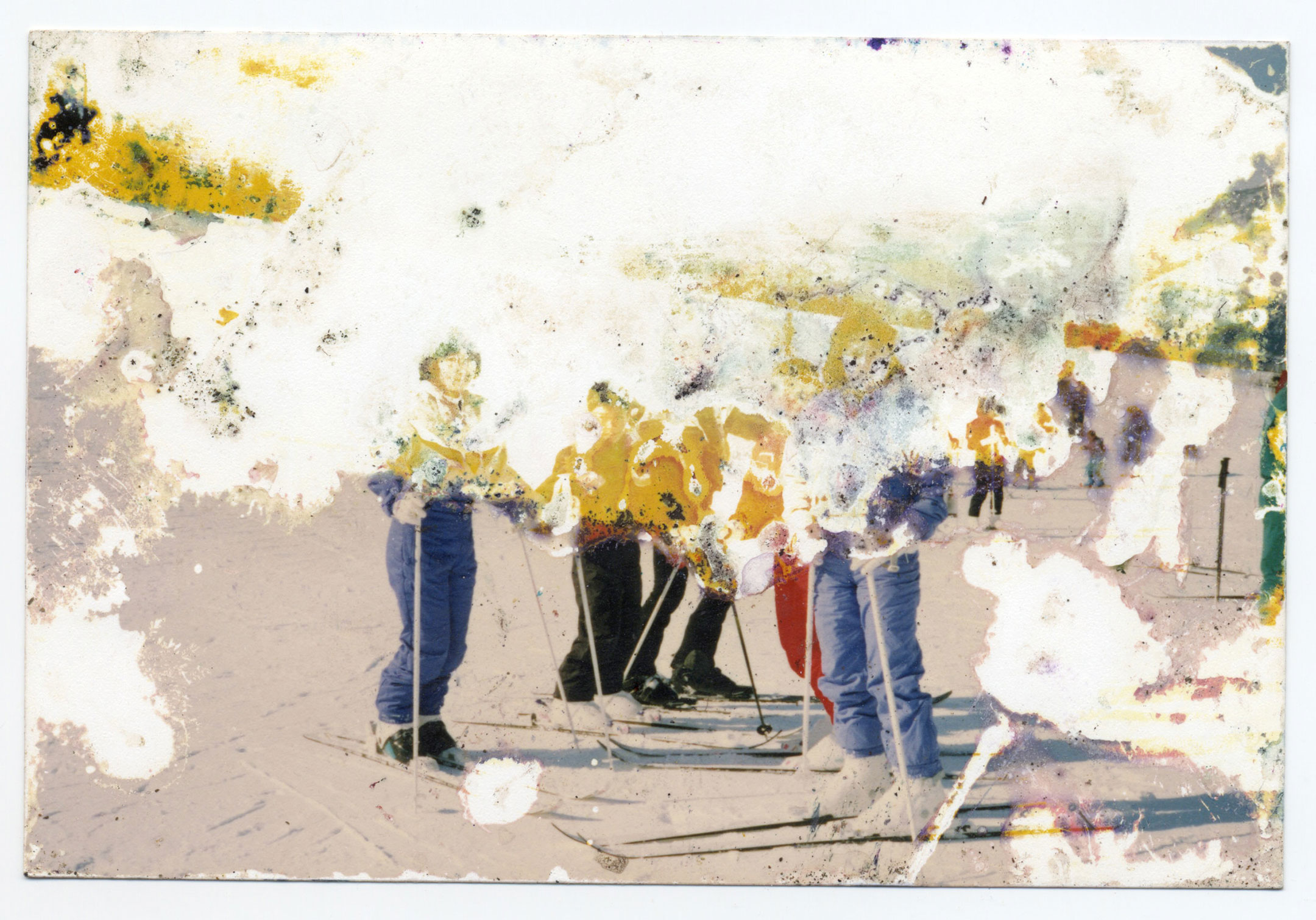 Photograph of five people skiing, but the top of the image is missing and bleached out