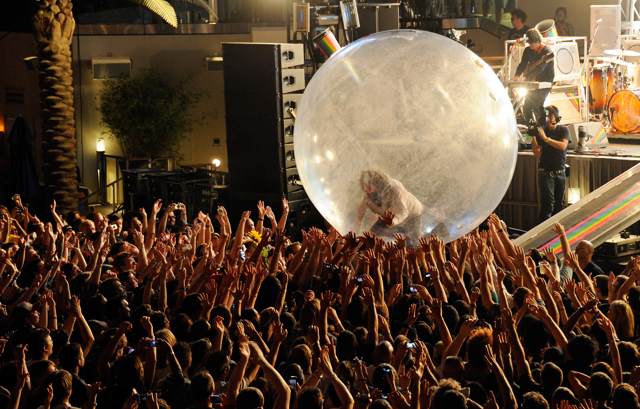 Photograph from a Flaming Lips concert showing lead singer Wayne Coyne in a bubble held aloft by the crowd of fans.