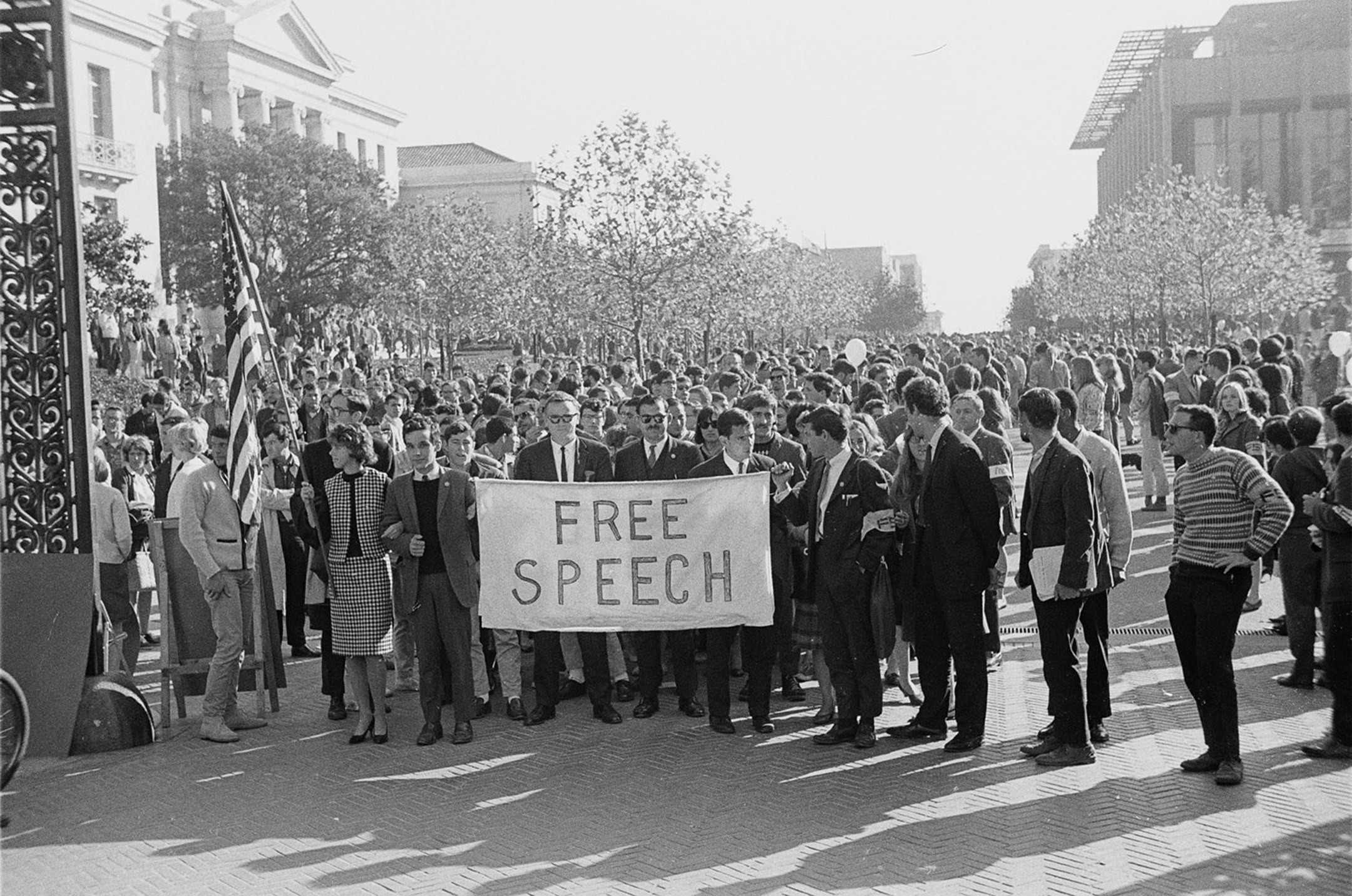 Black and white photo of marchers coming through Sather Gate with Free Speech sign to the UC Regents' meeting in University Hall to present their position on the Free Speech controversy at UC Berkley