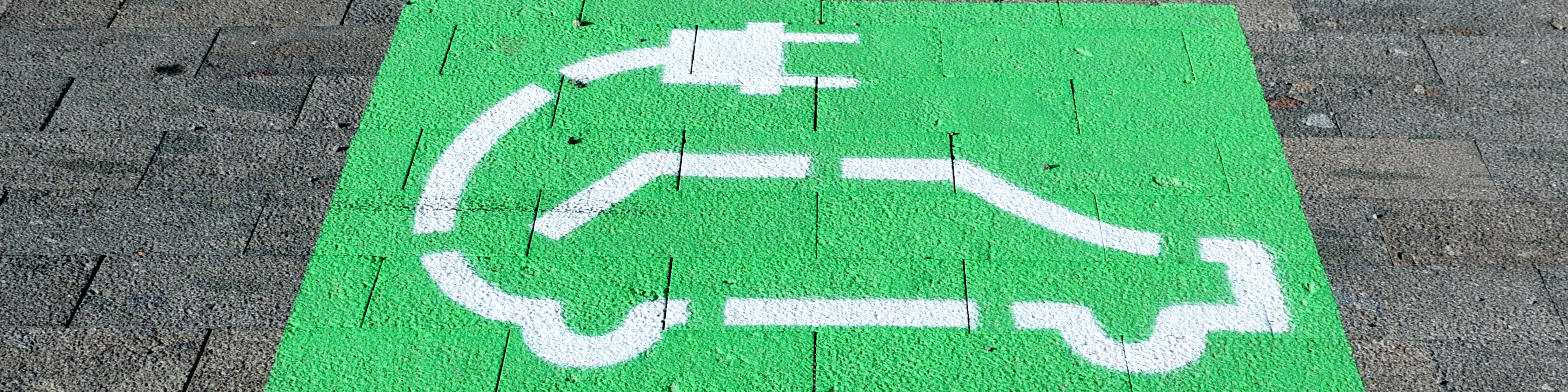 Green parking sign painting on a road to recharge electric car