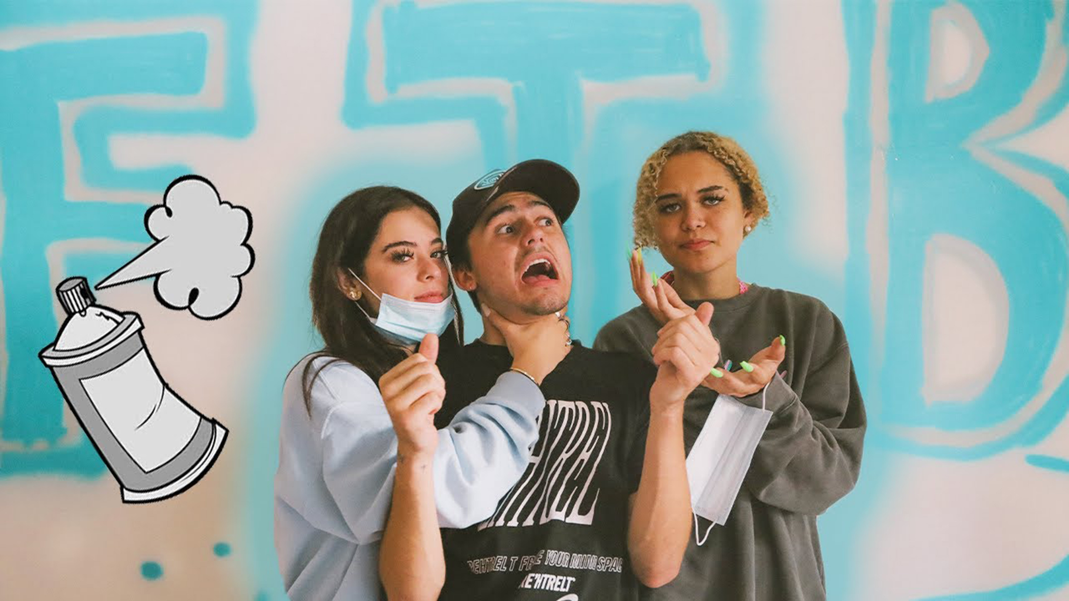 Three young people, two women with a man in between, make faces while standing in front of a white wall where the letters FTB have been spray painted in sky blue