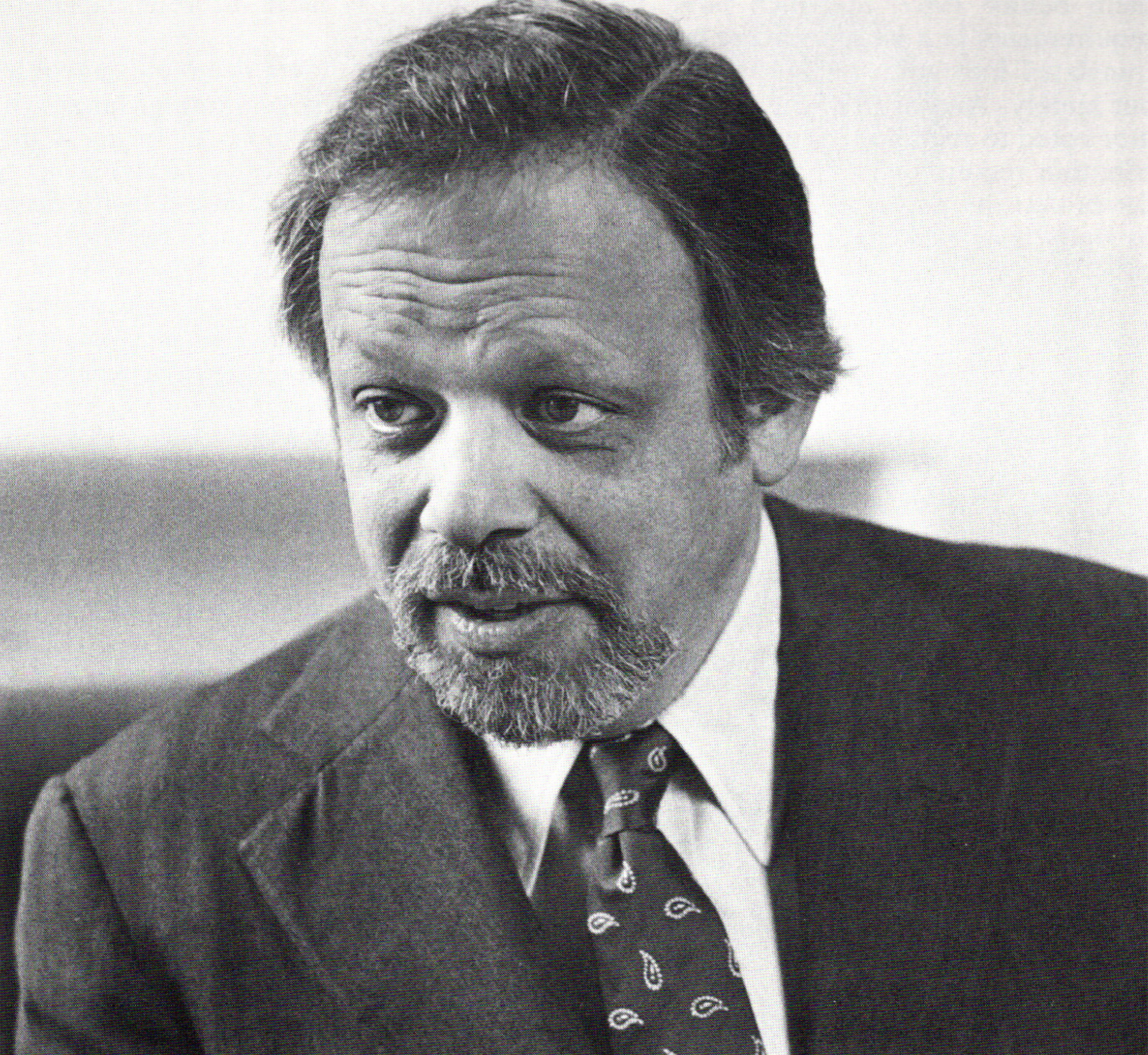 Black and white photo of A. Bartlett Giamatti looking to the left while in conversation