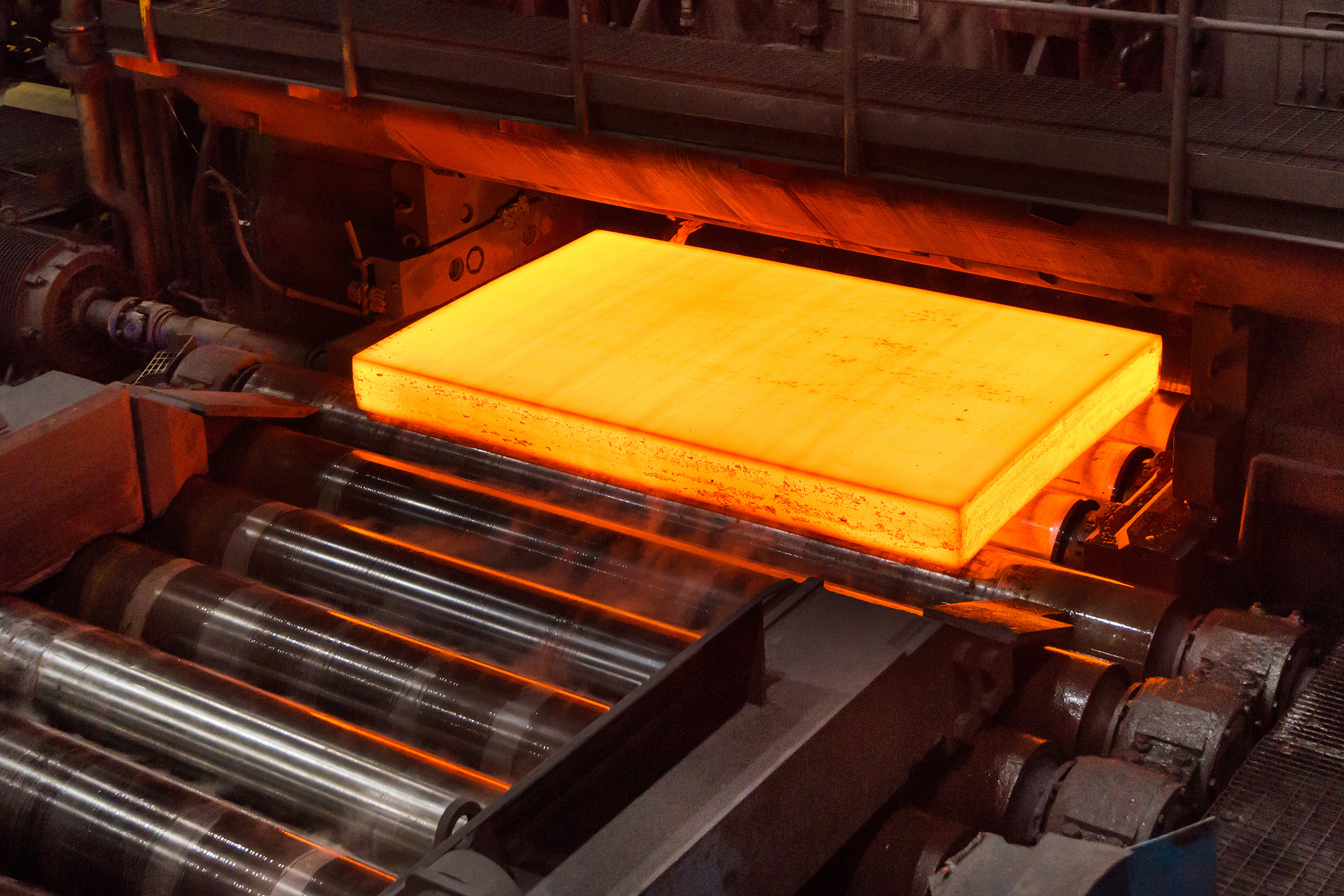Red-hot block of steel rolling off a mill machine