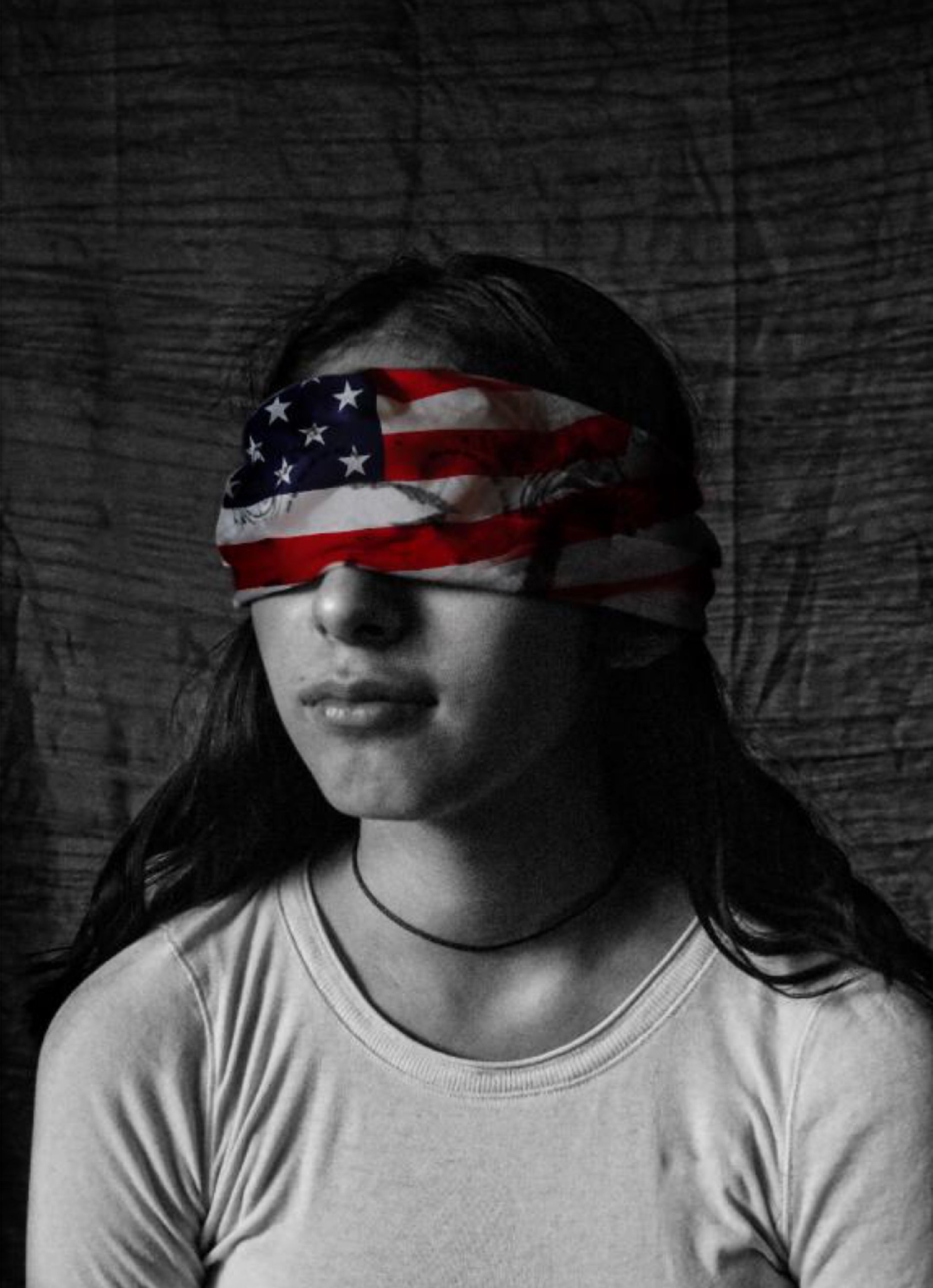 Black and white photo illustration of a young person wearing an American flag blindfold