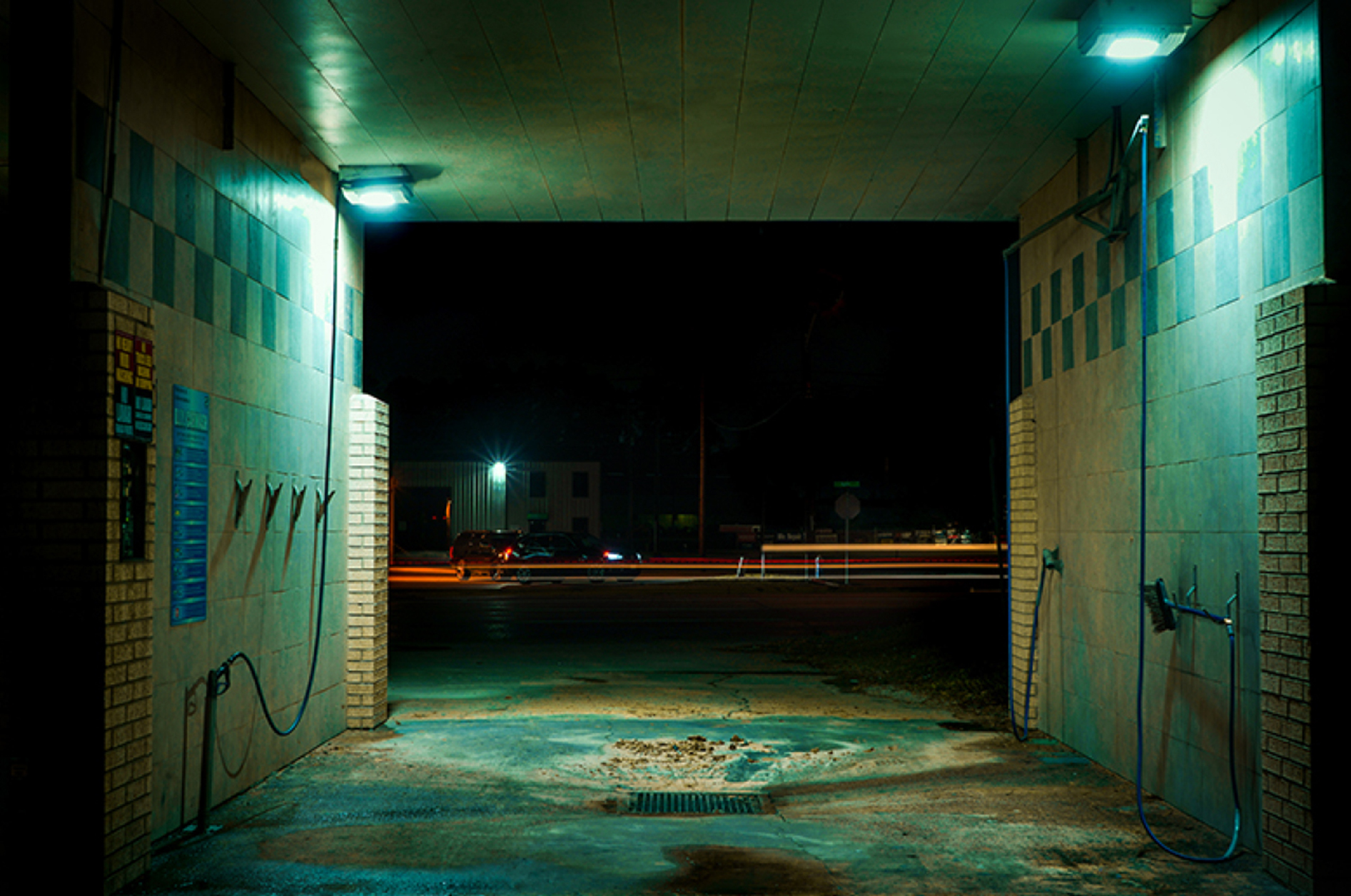Photo of an empty car wash stall at night
