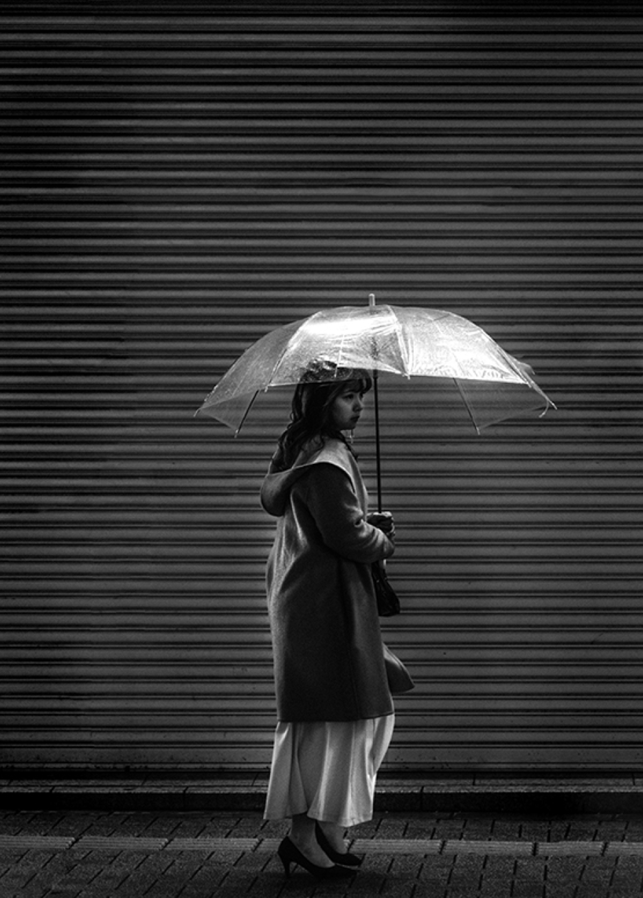 Black and white photo of a young woman holding an umbrella