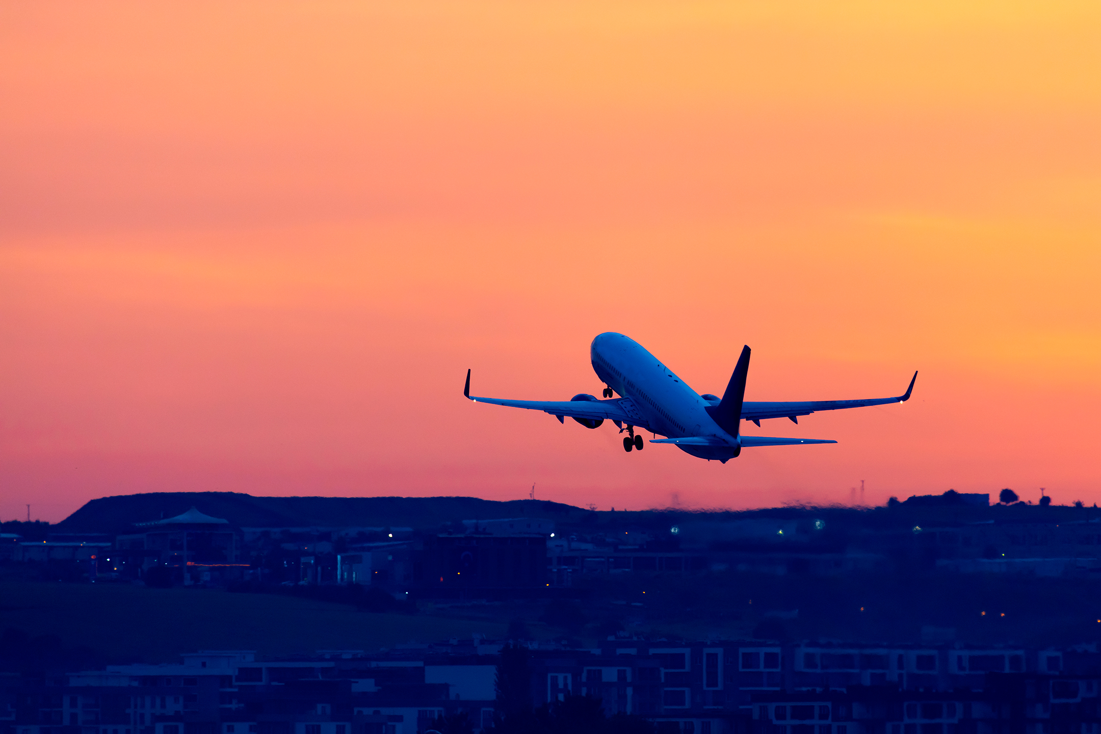 Passenger airplane taking off on sunset