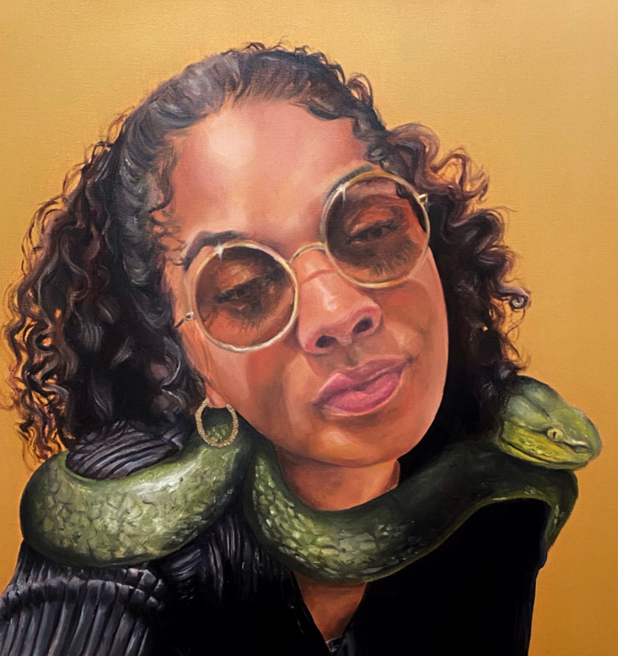 Portrait of a young black woman in sunglasses and with a green snake around her shoulders against a yellow background