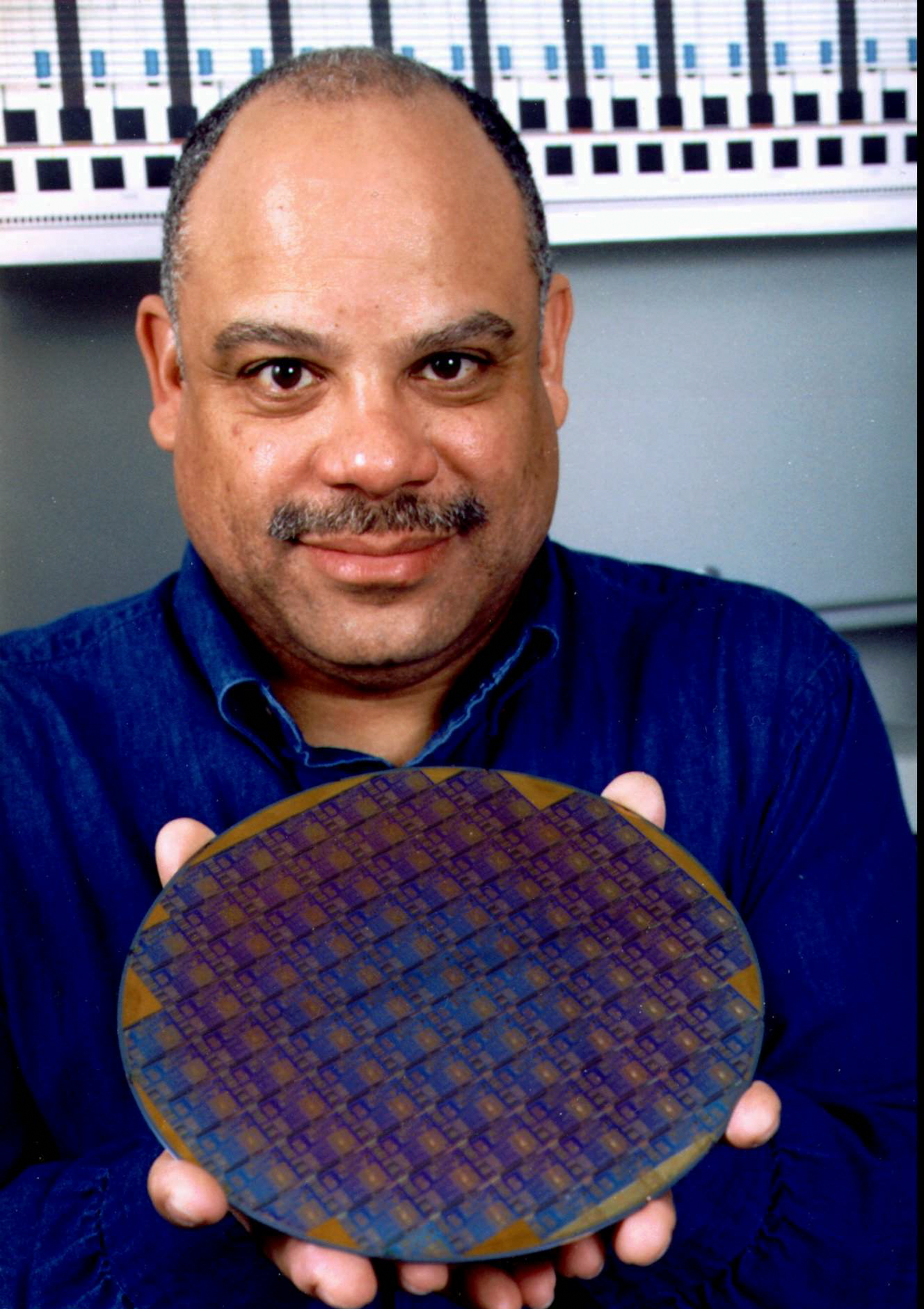Man holding a large circular computer chip
