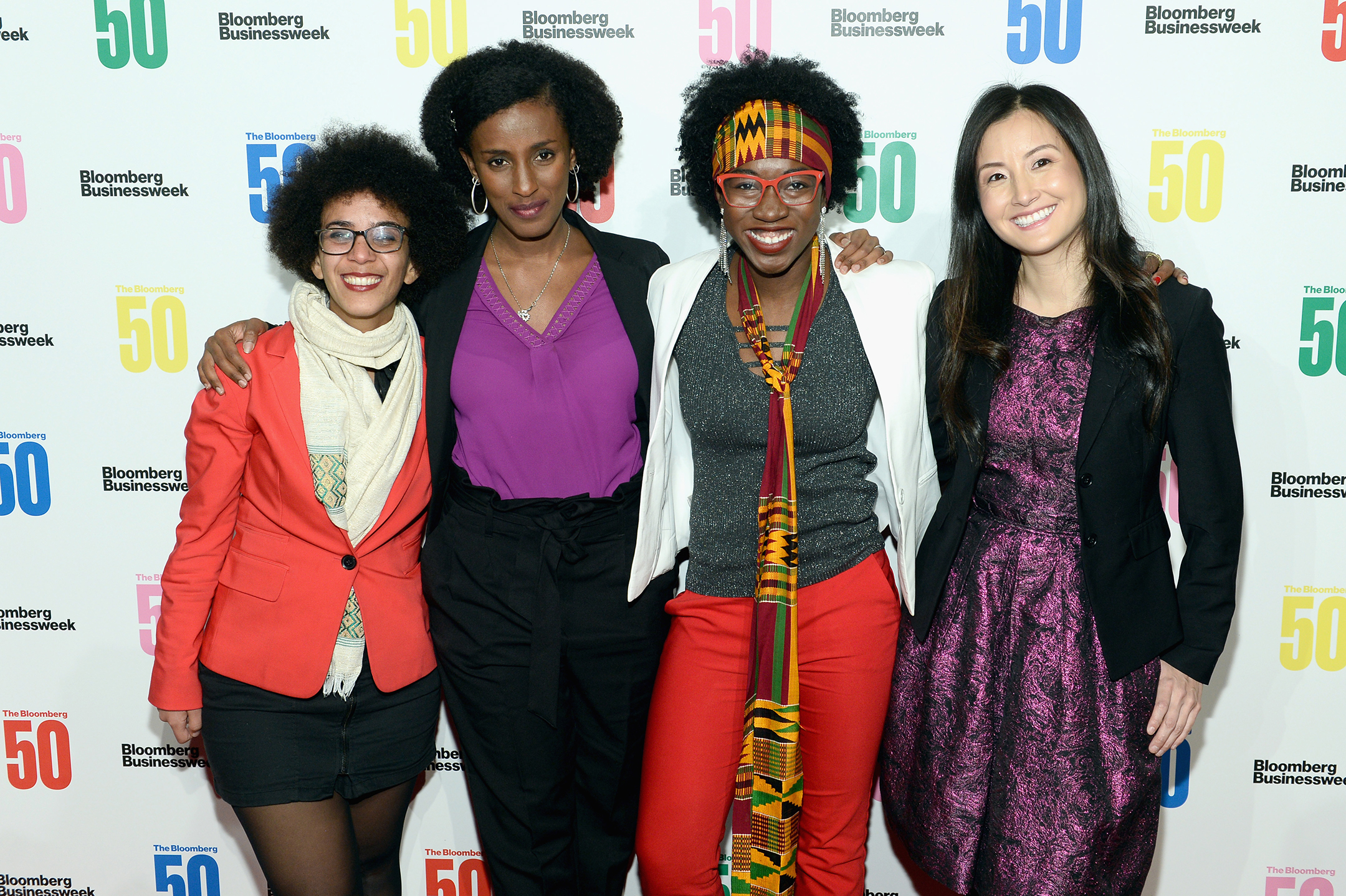 Photo of four women of color standing together and smiling at an event