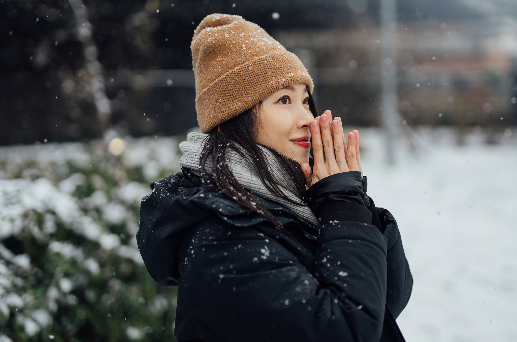 young Asian Woman Warming Her Hands In The Snow