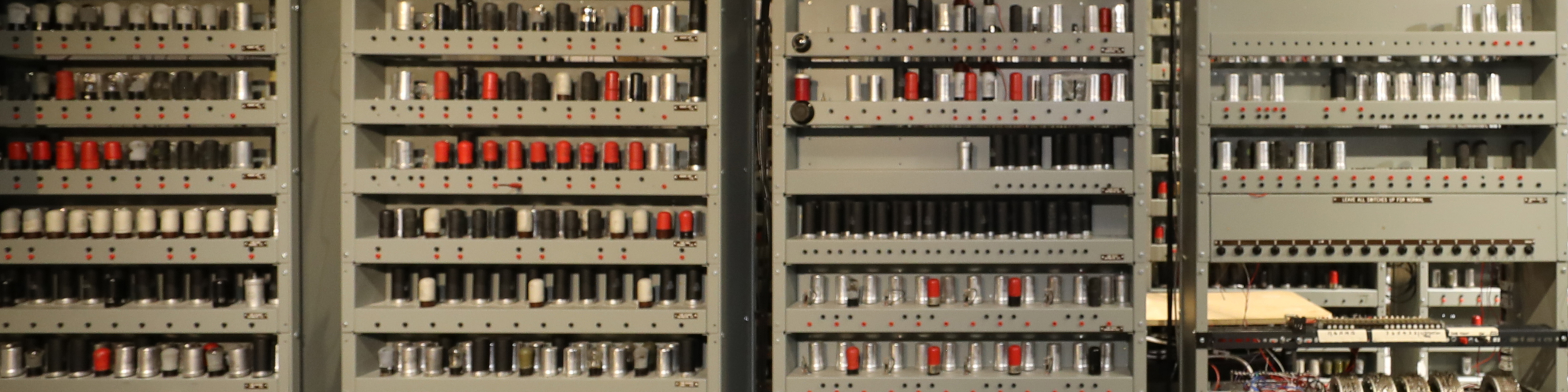 Detail of a recreation of the EDSAC computer, with valves in red and grey on long shelves
