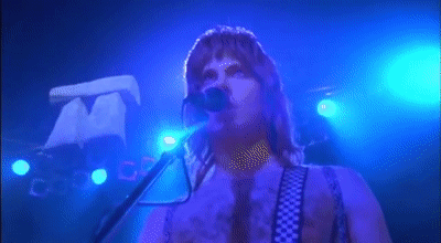 Gif of a scene from the movie This is Spinal tap, featuring a tiny replica of Stonehenge descending toward a stage
