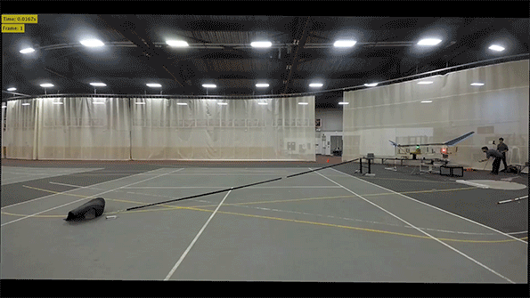 Animated gif of a test airplane flying across a gymnasium