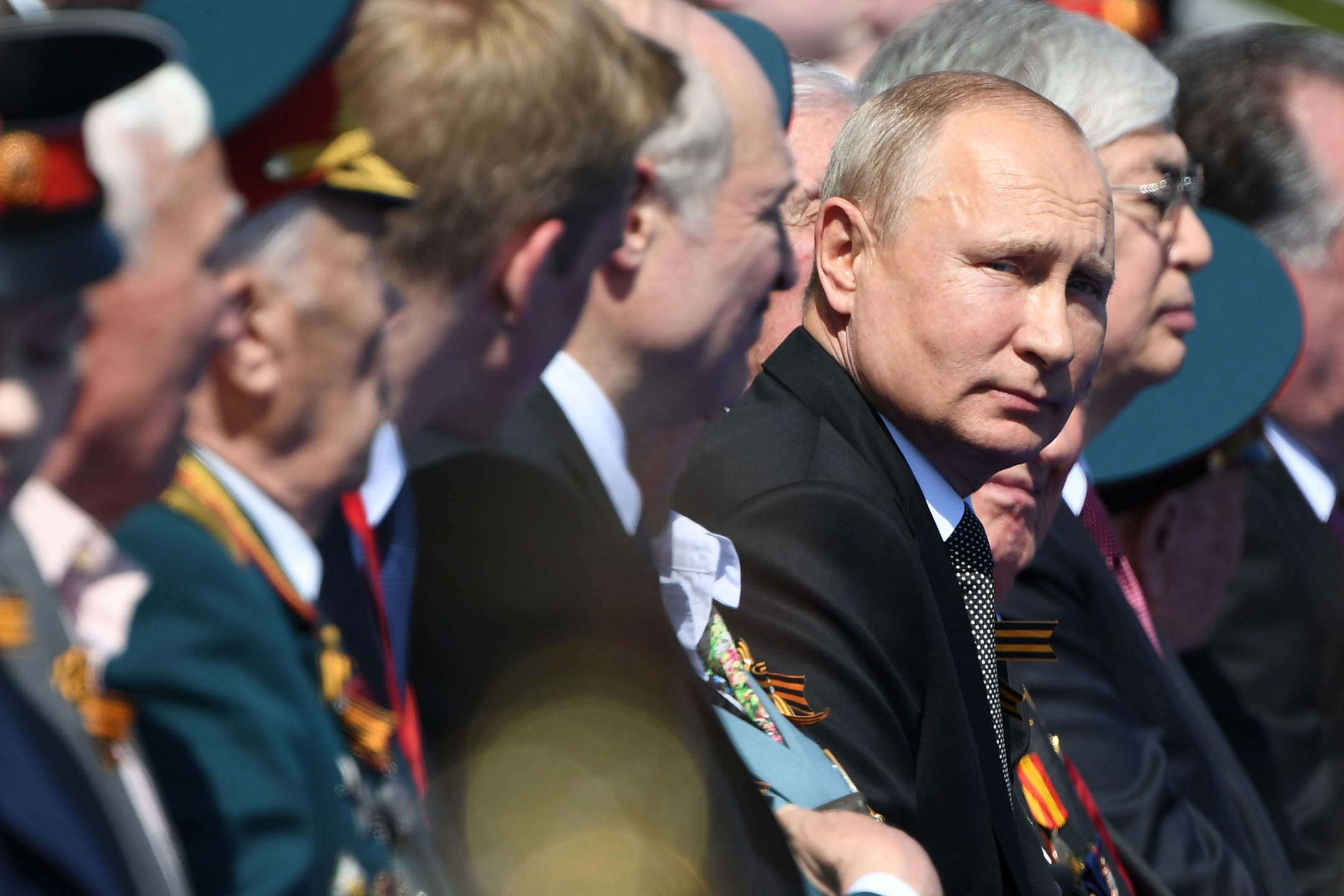 Vladimir Putin seated among generals and lawmakers