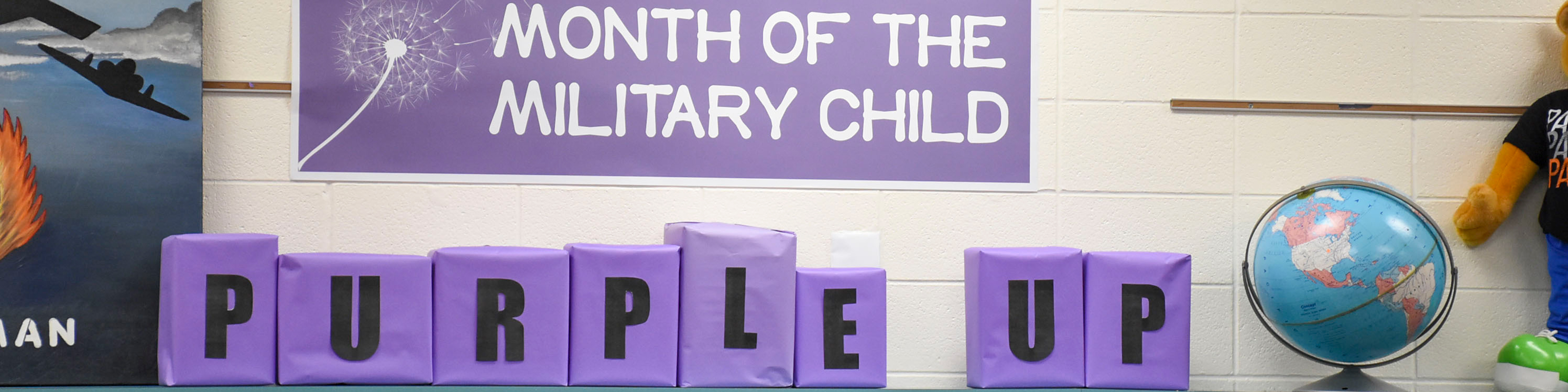 Purple Up decorations atop a school library bookcase