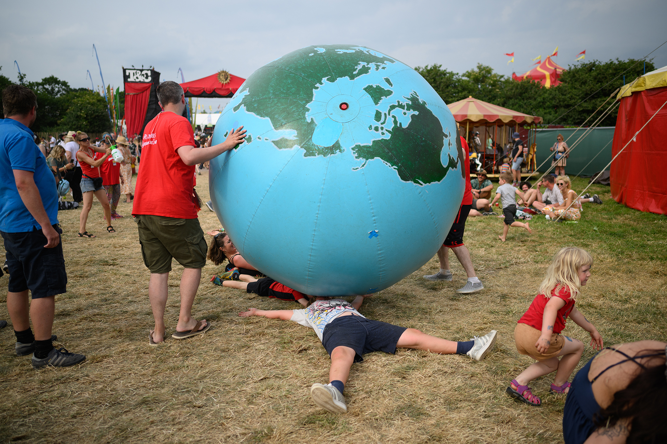 People playing with a giant inflatable globe in a field