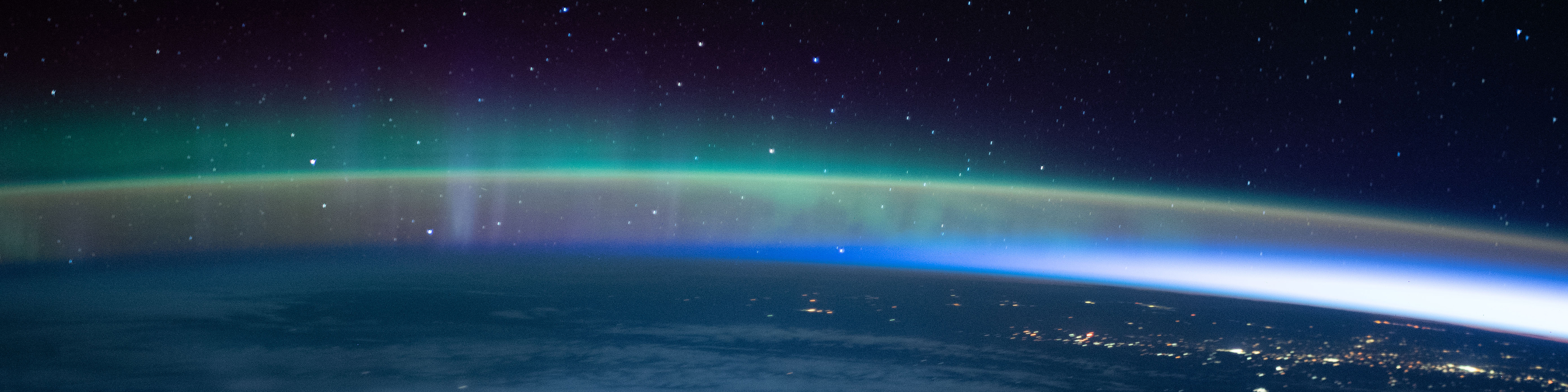 In this image taken on Oct. 30, 2021, an aurora dimly intersected with Earth's airglow as the International Space Station flew into an orbital sunrise 264 miles above the Pacific Ocean before crossing over Canada.
