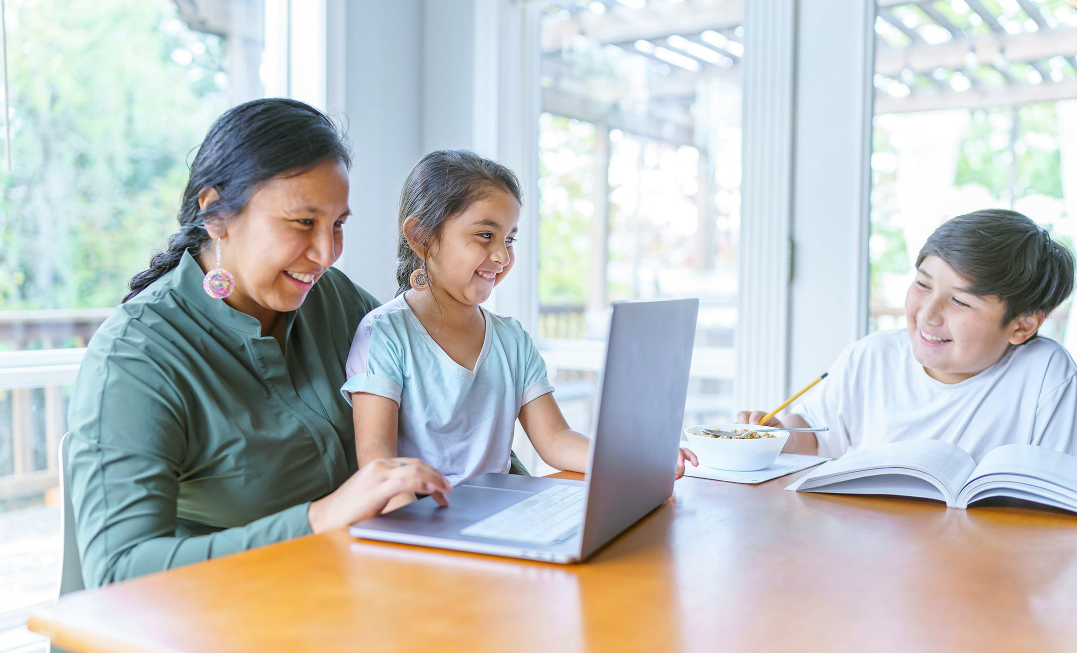 Mom helping elementary age girl with e-learning video conference call