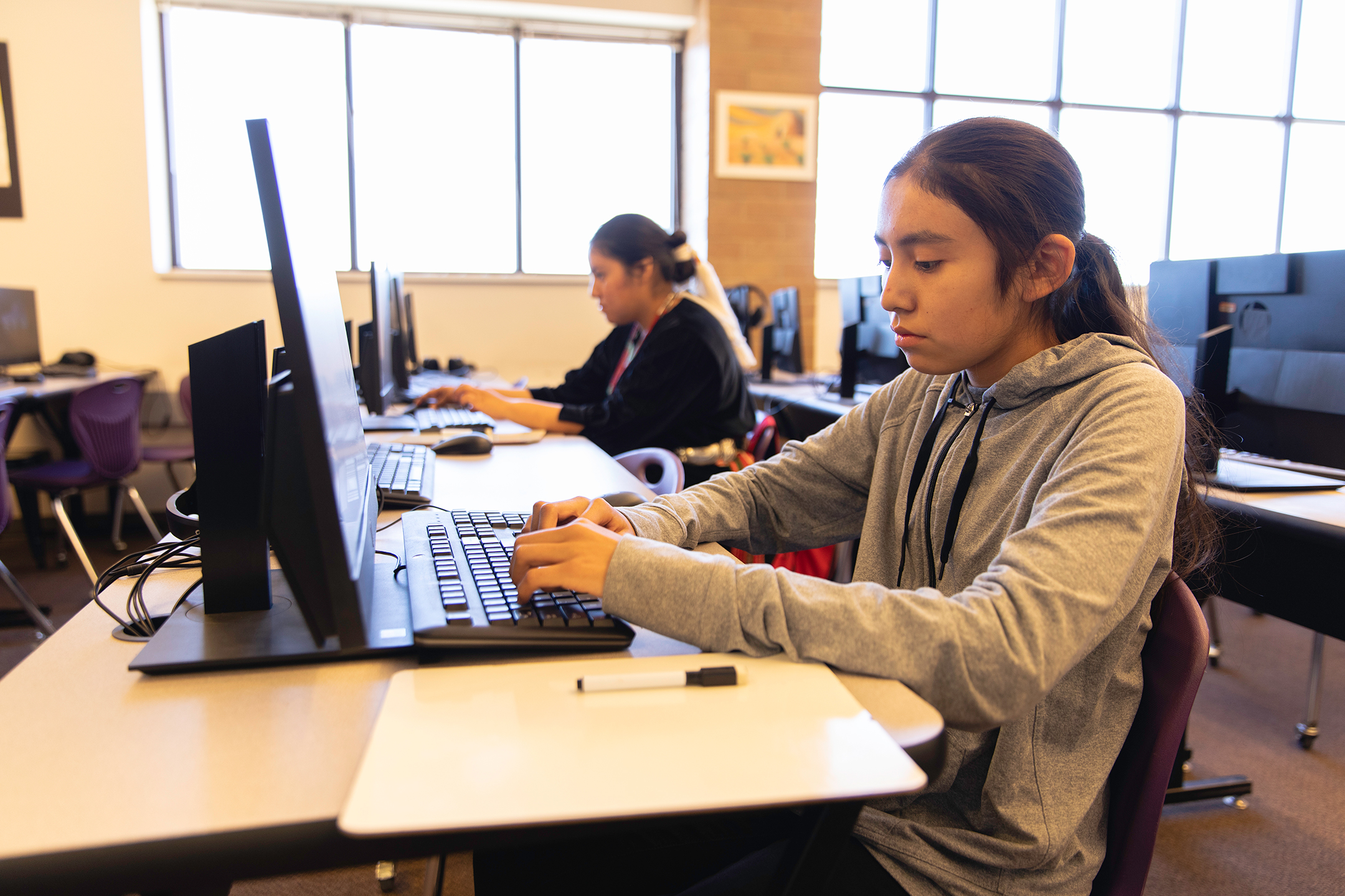Two Navajo high school students work on computers in the library. Image taken on the Navajo Reservation, Utah, USA.