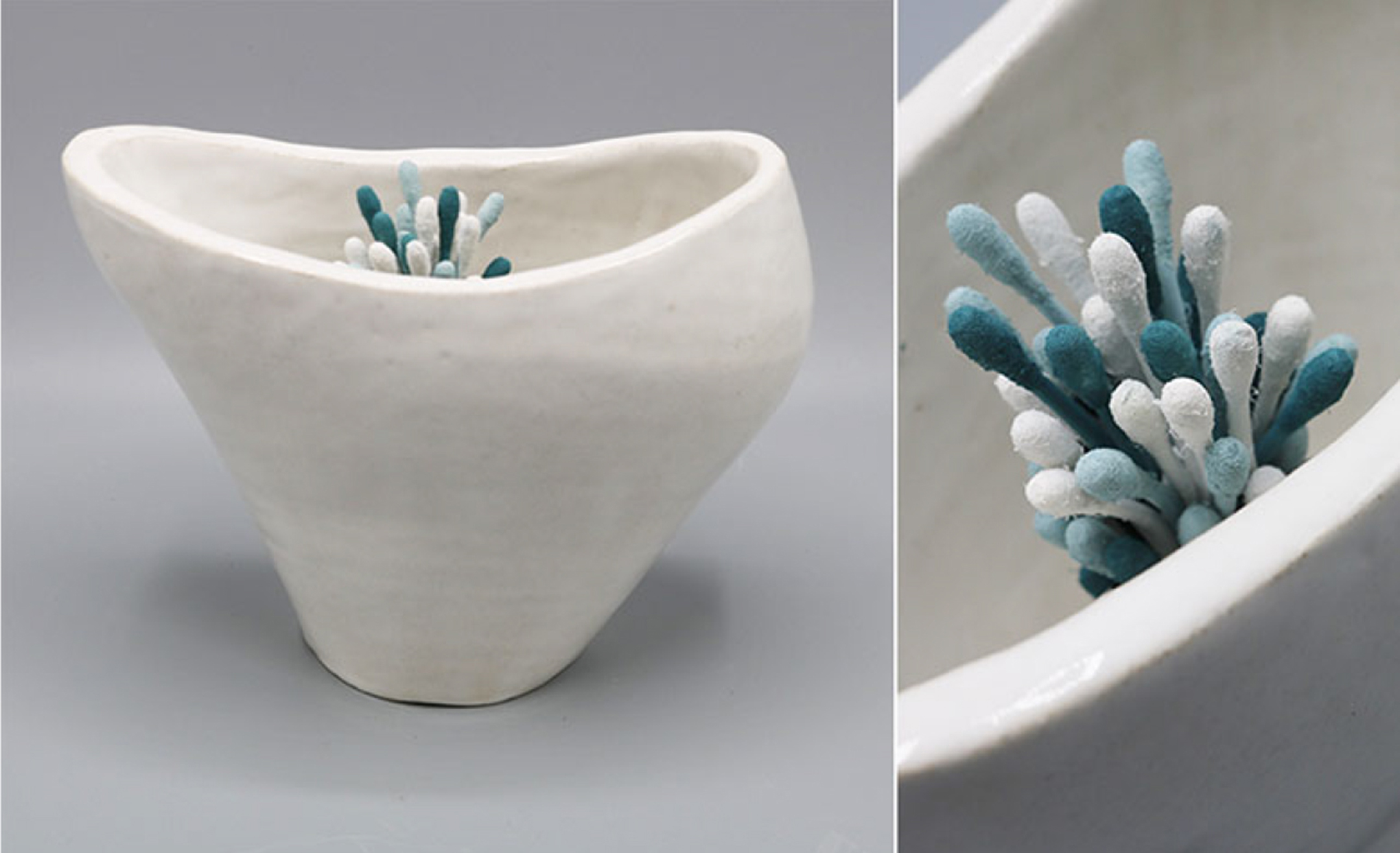 sculpture of a white cup-like object with a small cluster of blue-and-white Q-tips poking out of the top