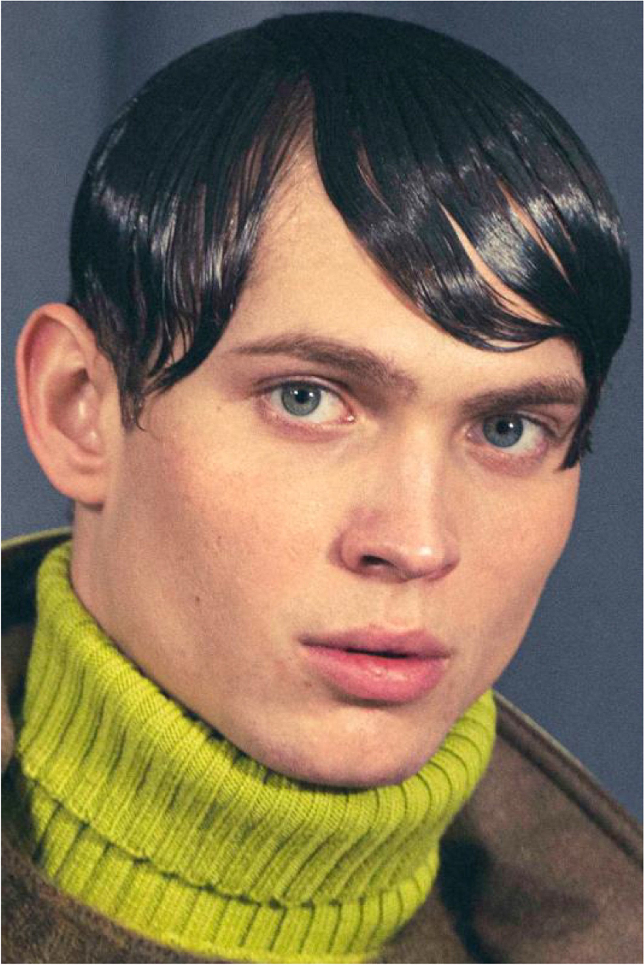 photograph of a young white man with slicked down black hair and green turtleneck
