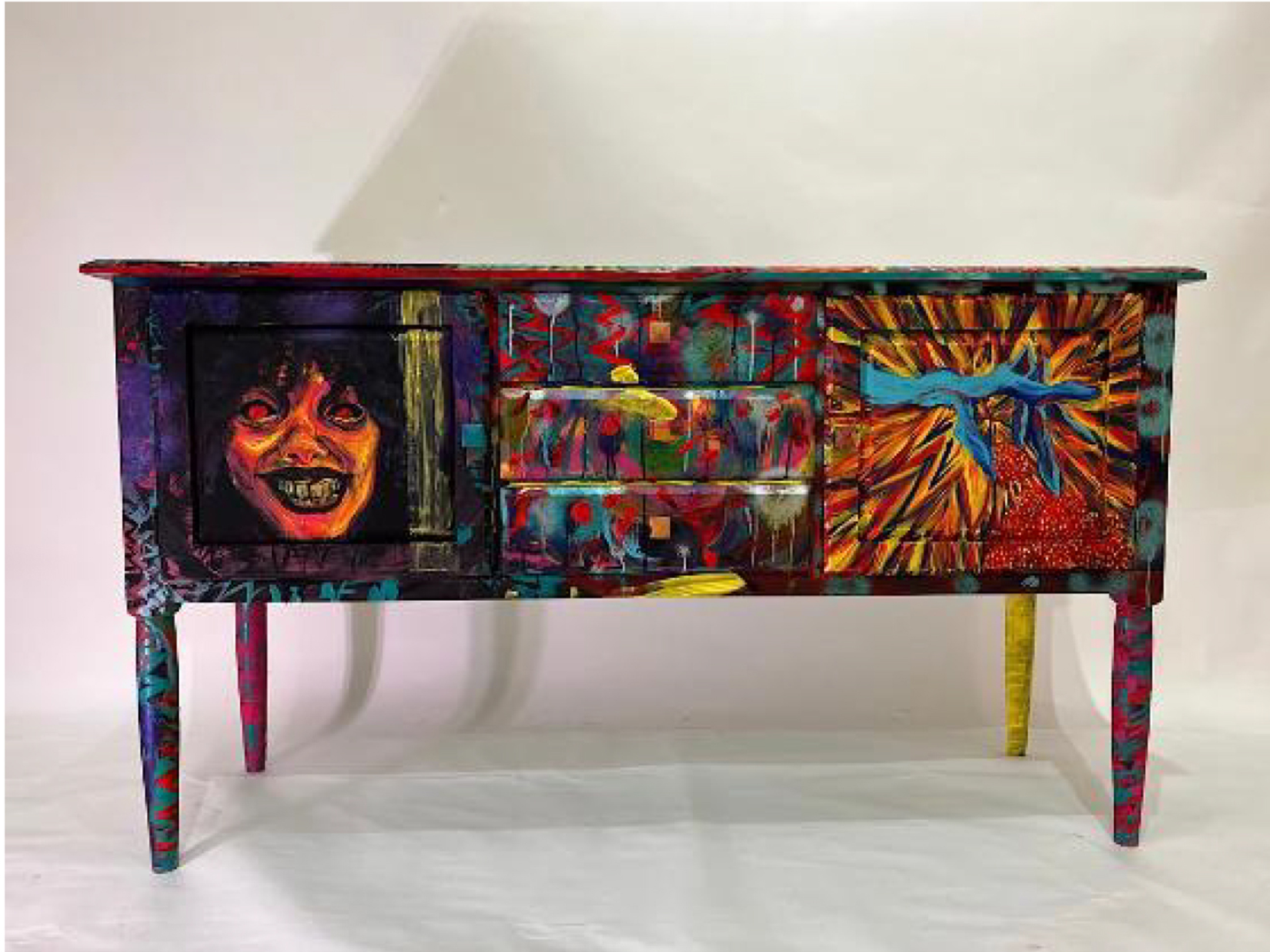 a three-drawer, two cabinet table painted with colors and imagery