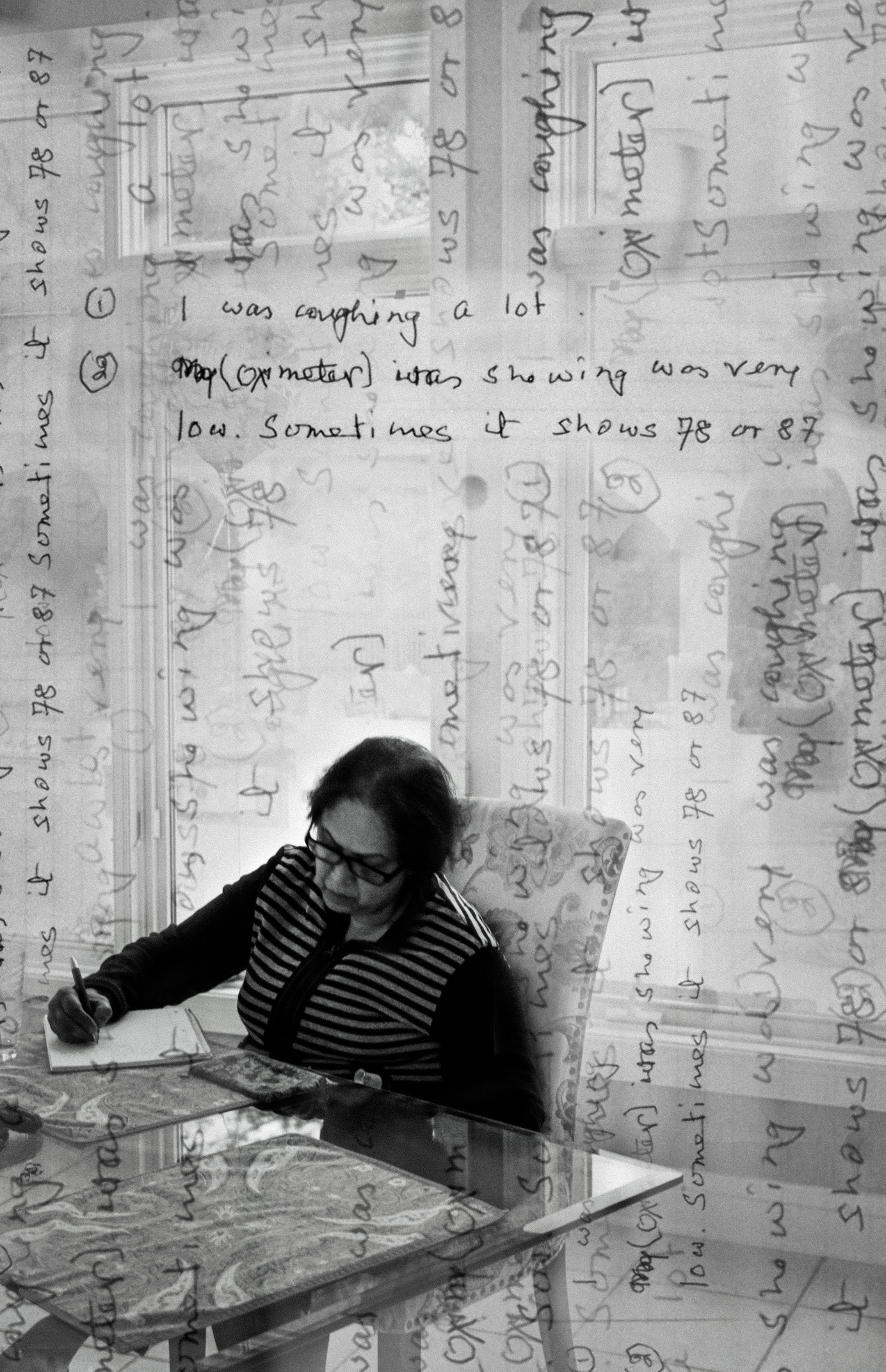 black and white photo of an older woman writing in a notebook while sitting at a table, with words and handwriting superimposed on the image