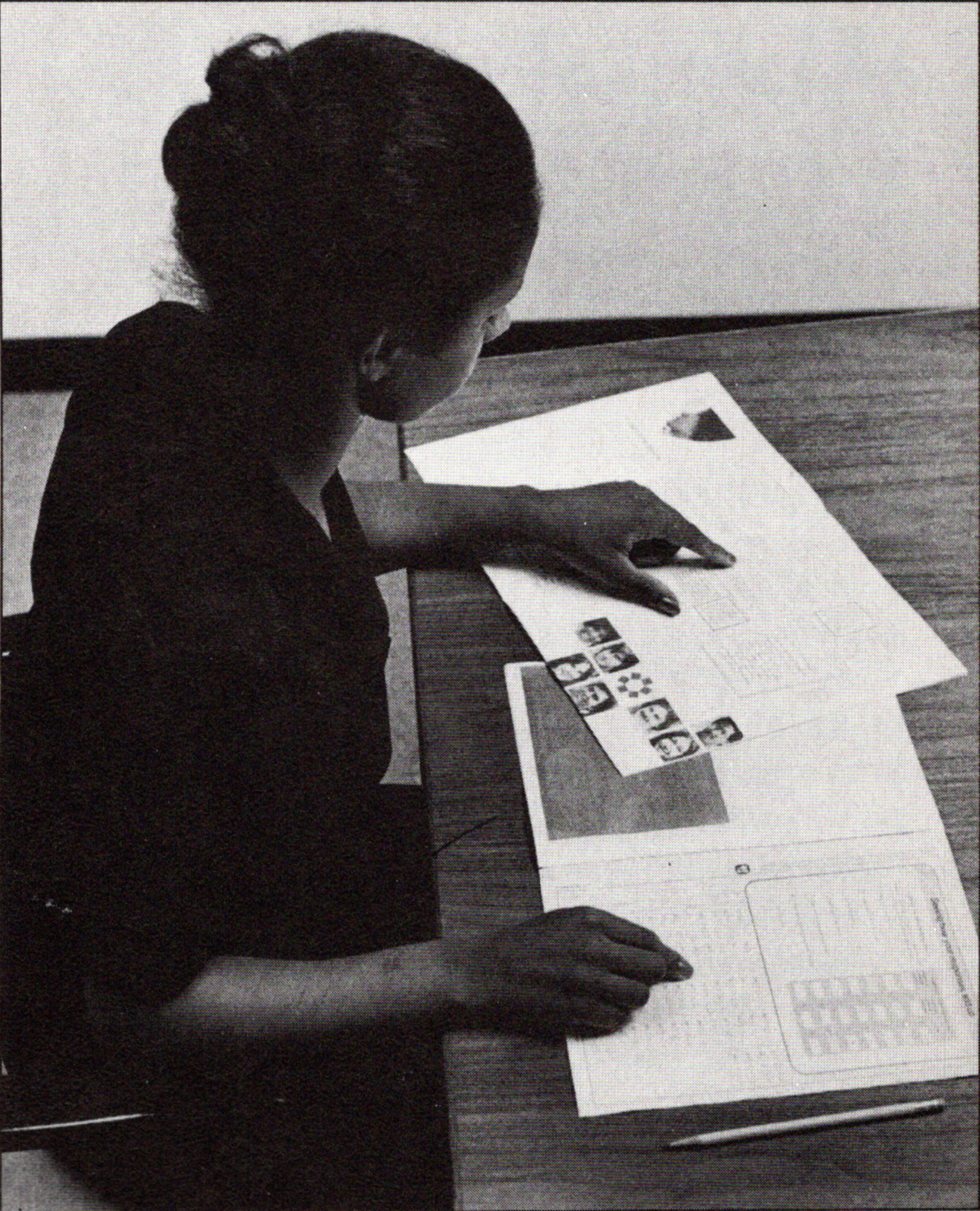 black and white photo of a student seated at a desk taking an assessment test