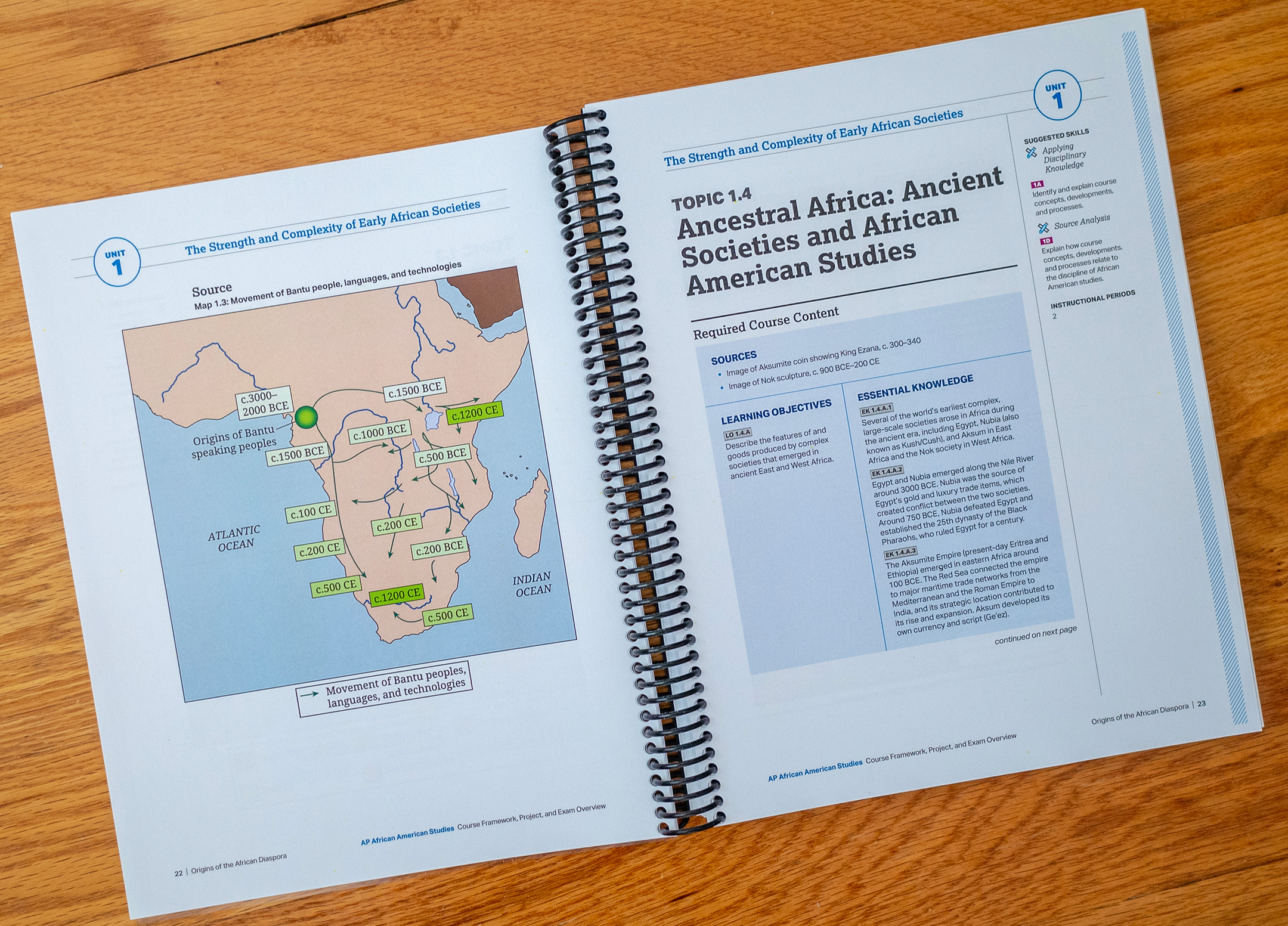spiral-bound volume opened to show a map of africa on the left and a page of text on the right with the header Topic 1.4 Ancestral Africa: Ancient Societies and African American Studies